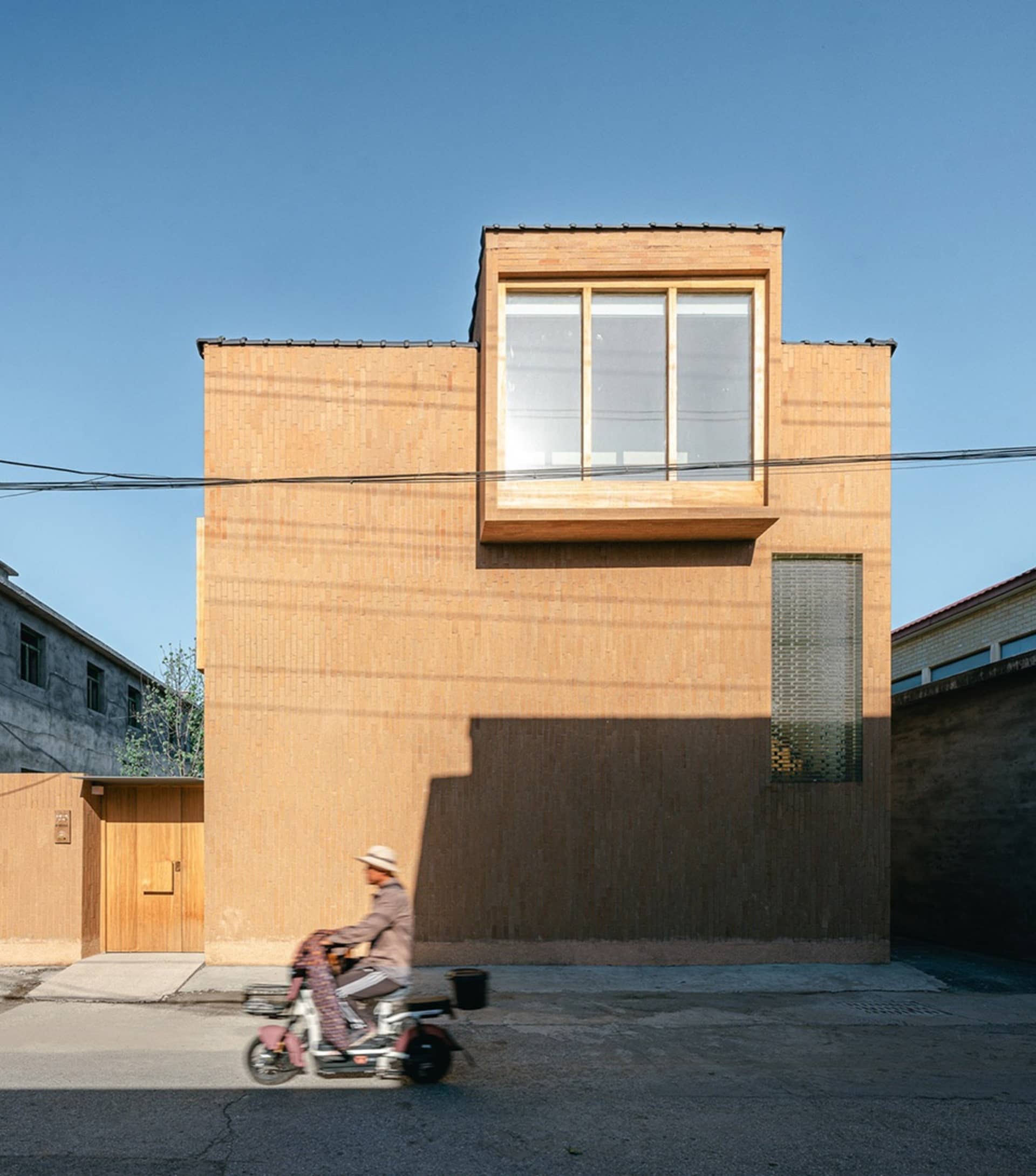 A modern building with a unique wooden facade and large windows.