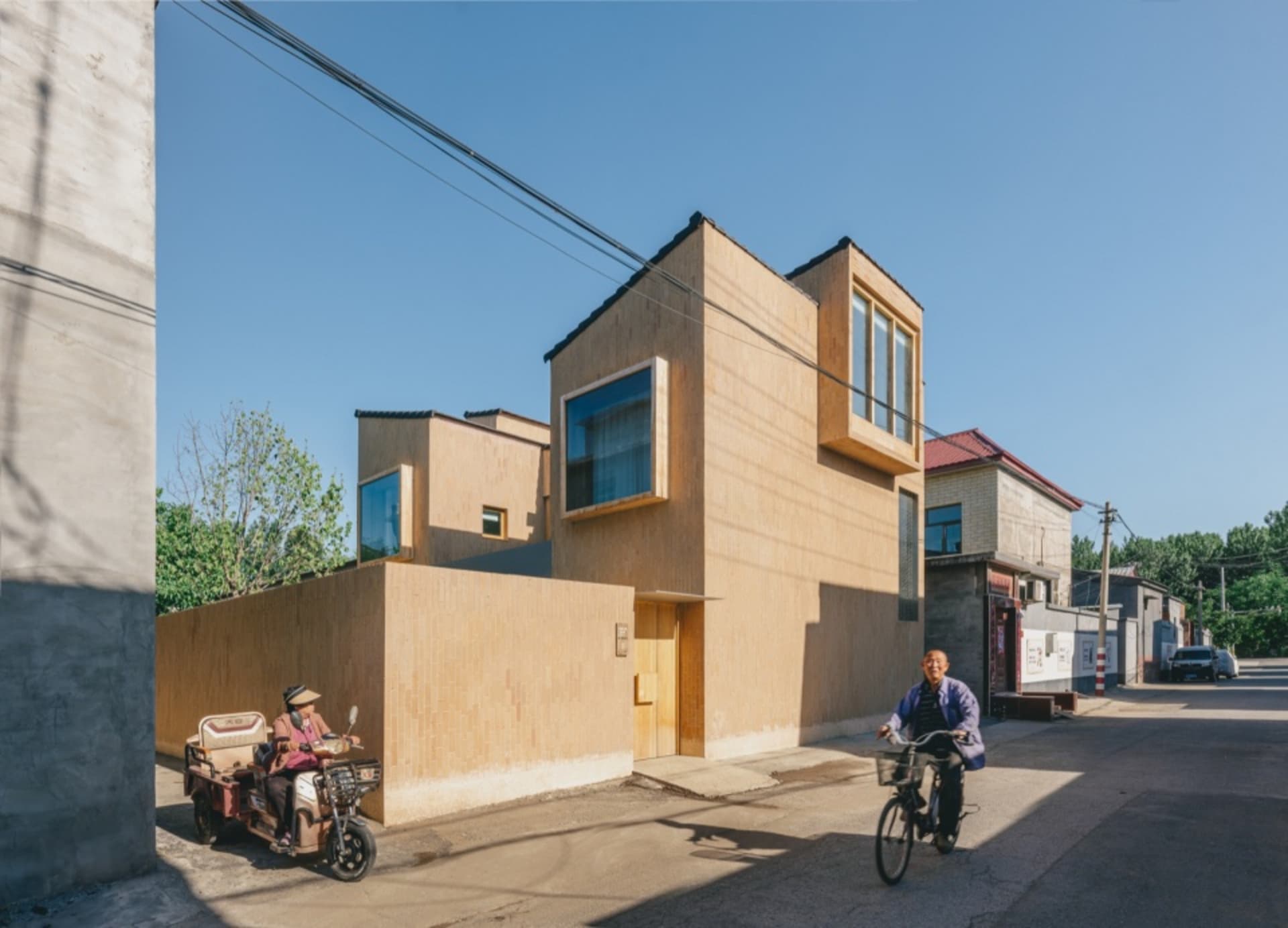 A modern street scene with a concrete building and a clear blue sky.