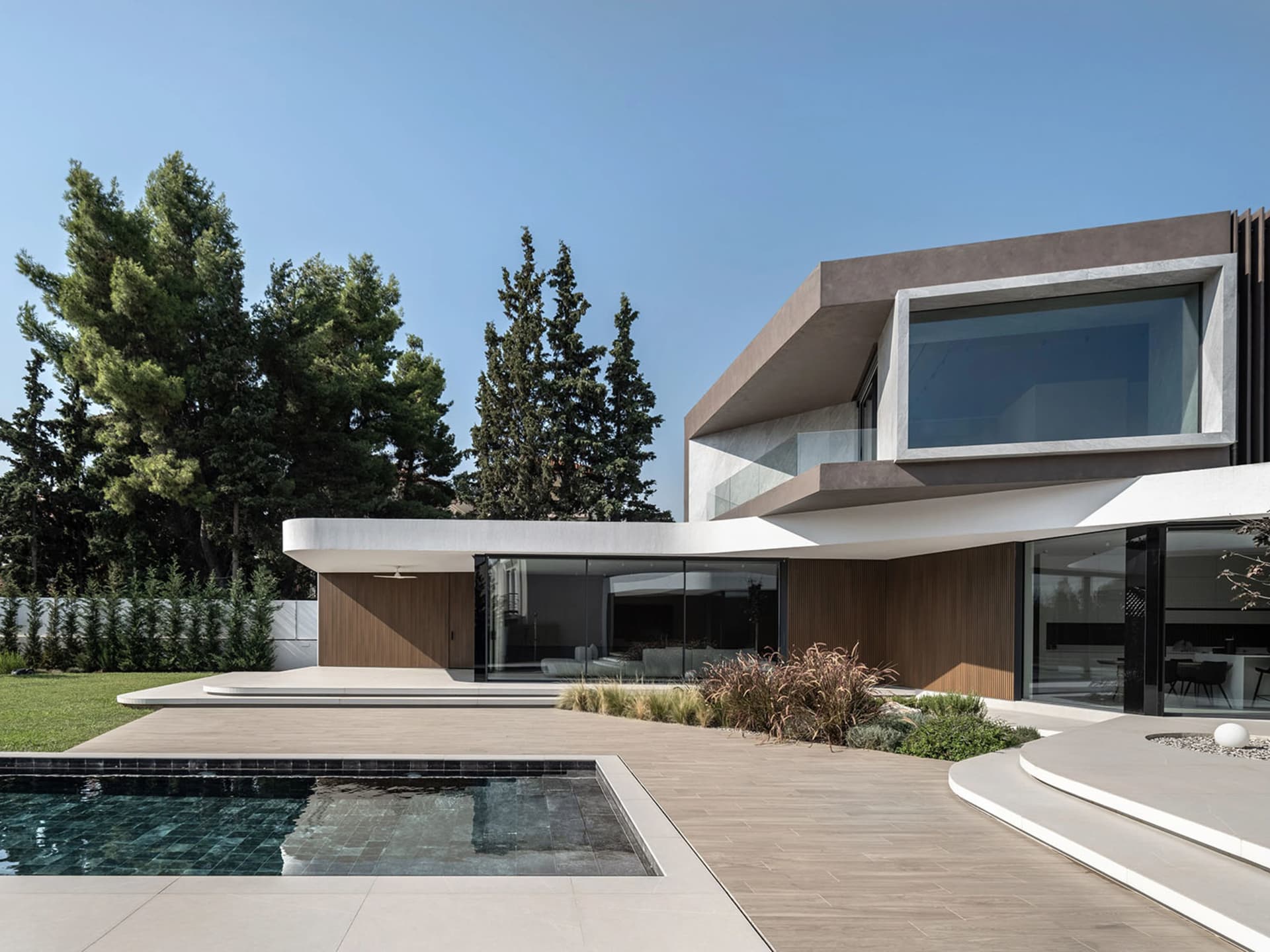 A modern house featuring a sleek concrete and glass exterior.