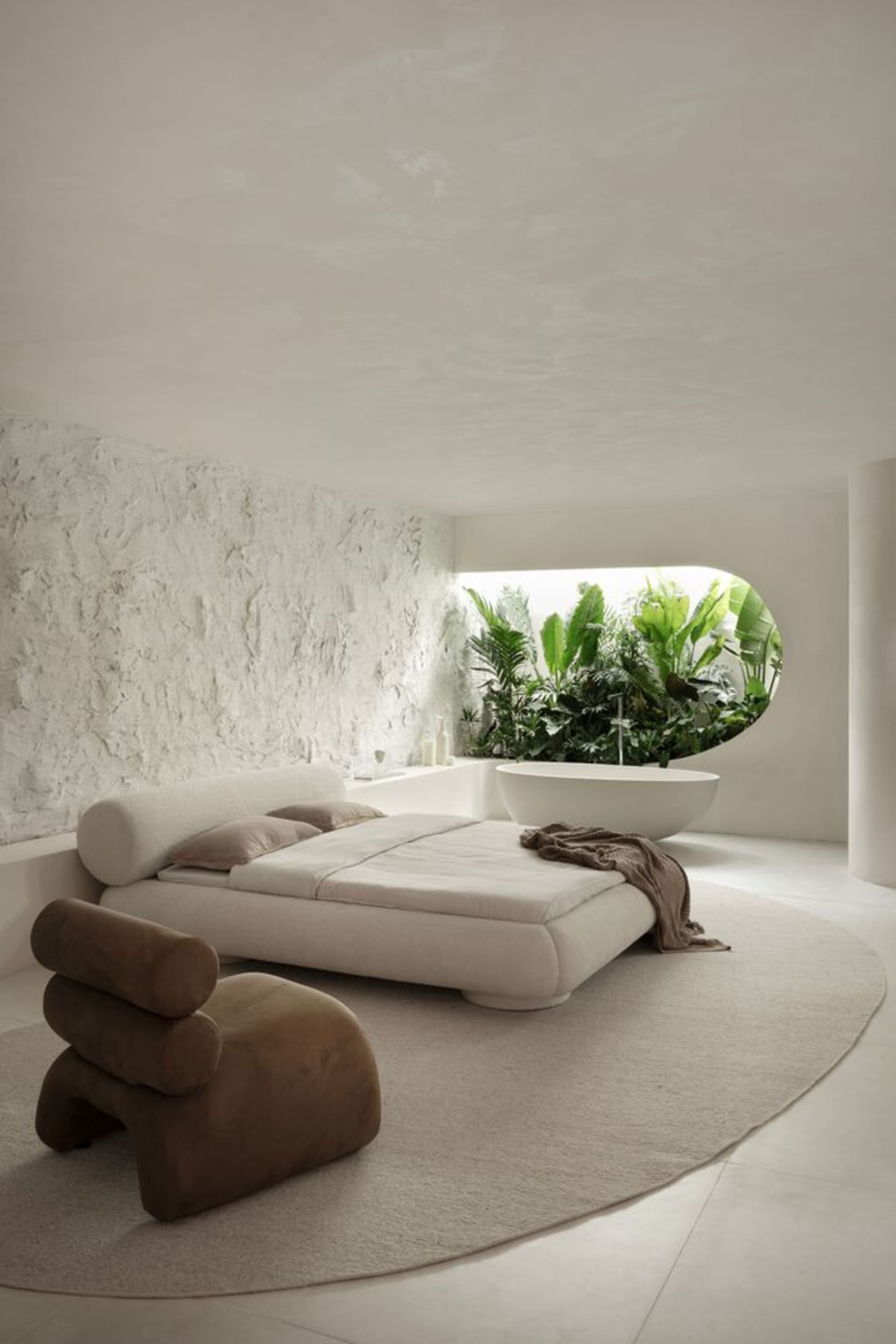 A modern minimalist bedroom with a concrete bed frame and plant-filled bathtub