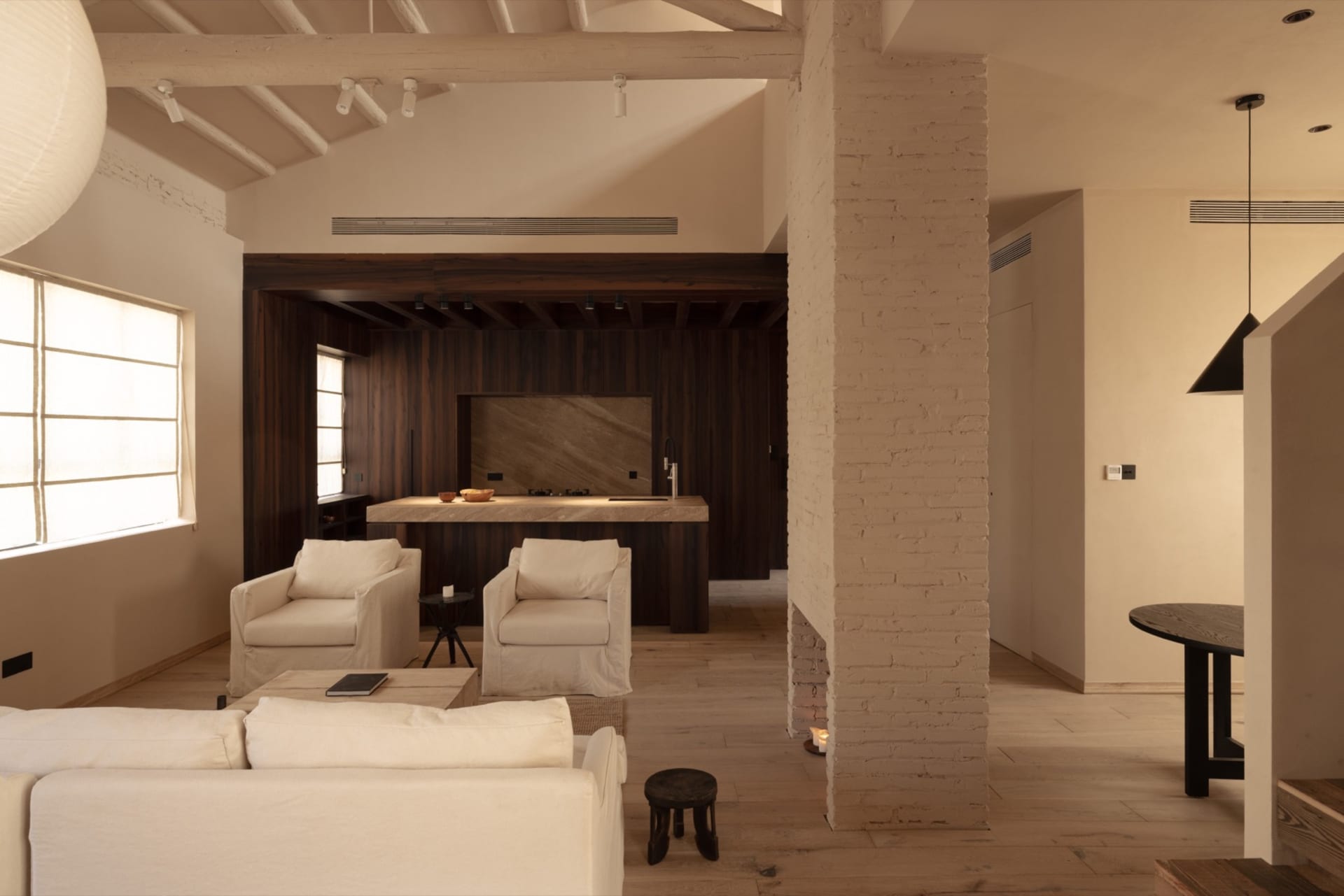A minimalist living room with wooden furniture and a white sofa.