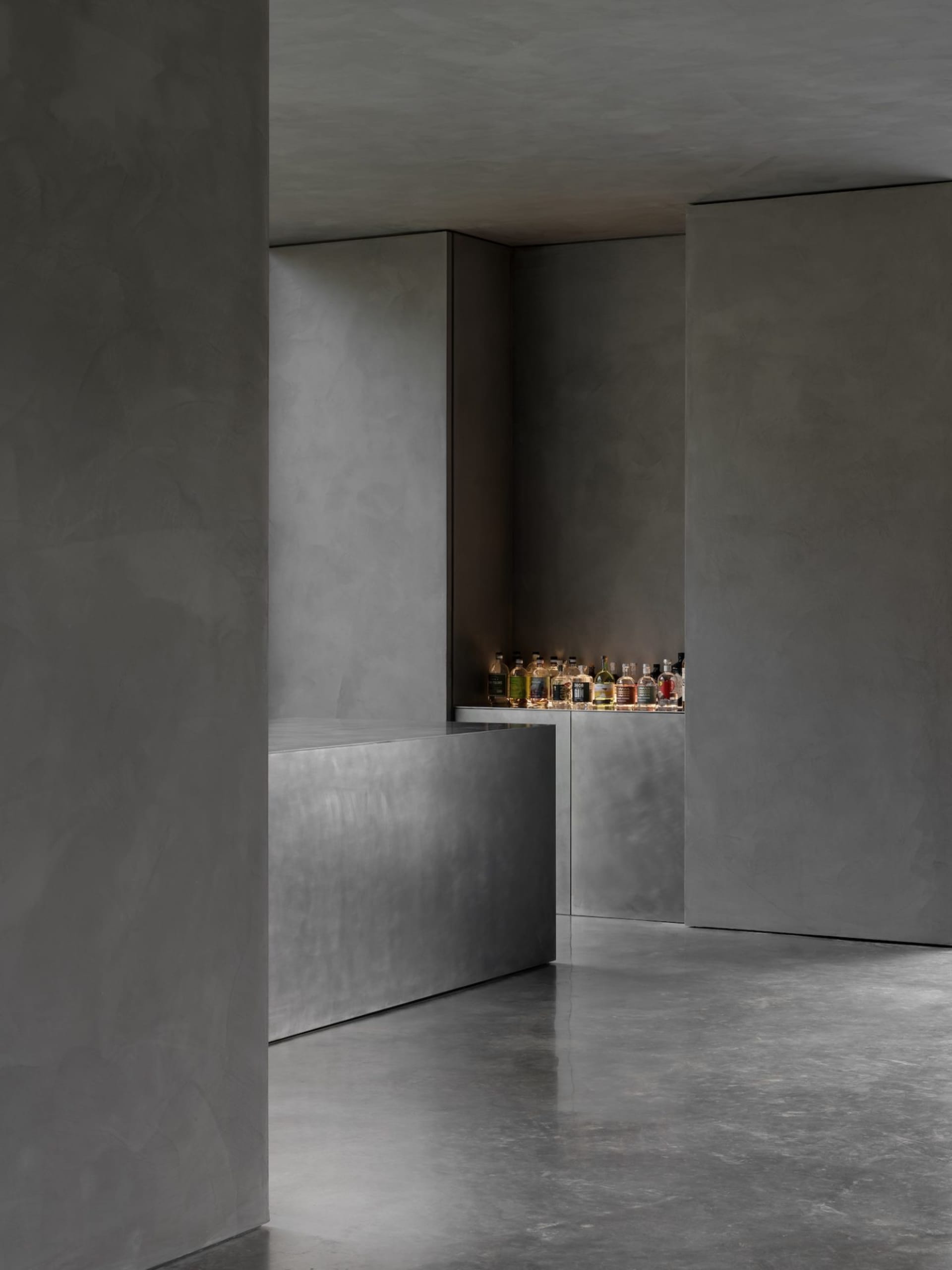 Modern industrial-style bar counter made of concrete, featuring a sleek design with a minimalist aesthetic.