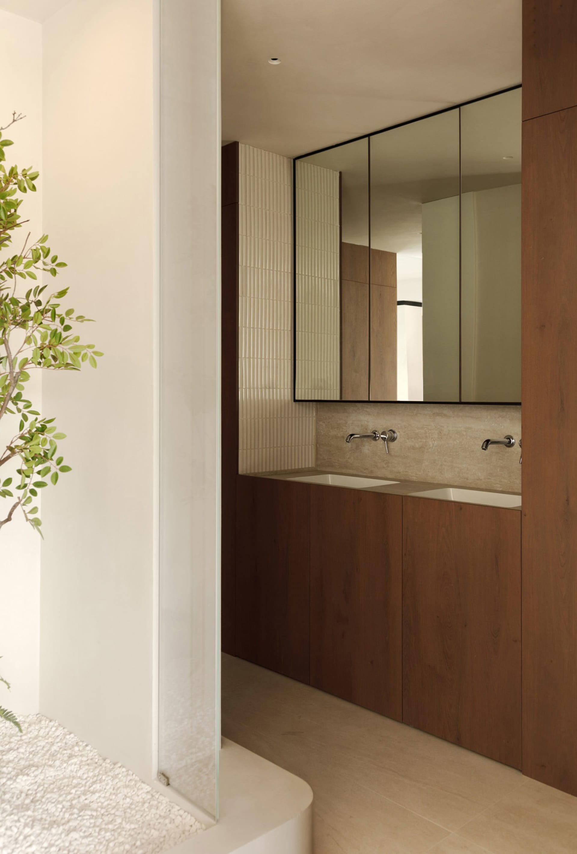 Modern minimalist bathroom with wooden cabinets and ceramic tile accents.