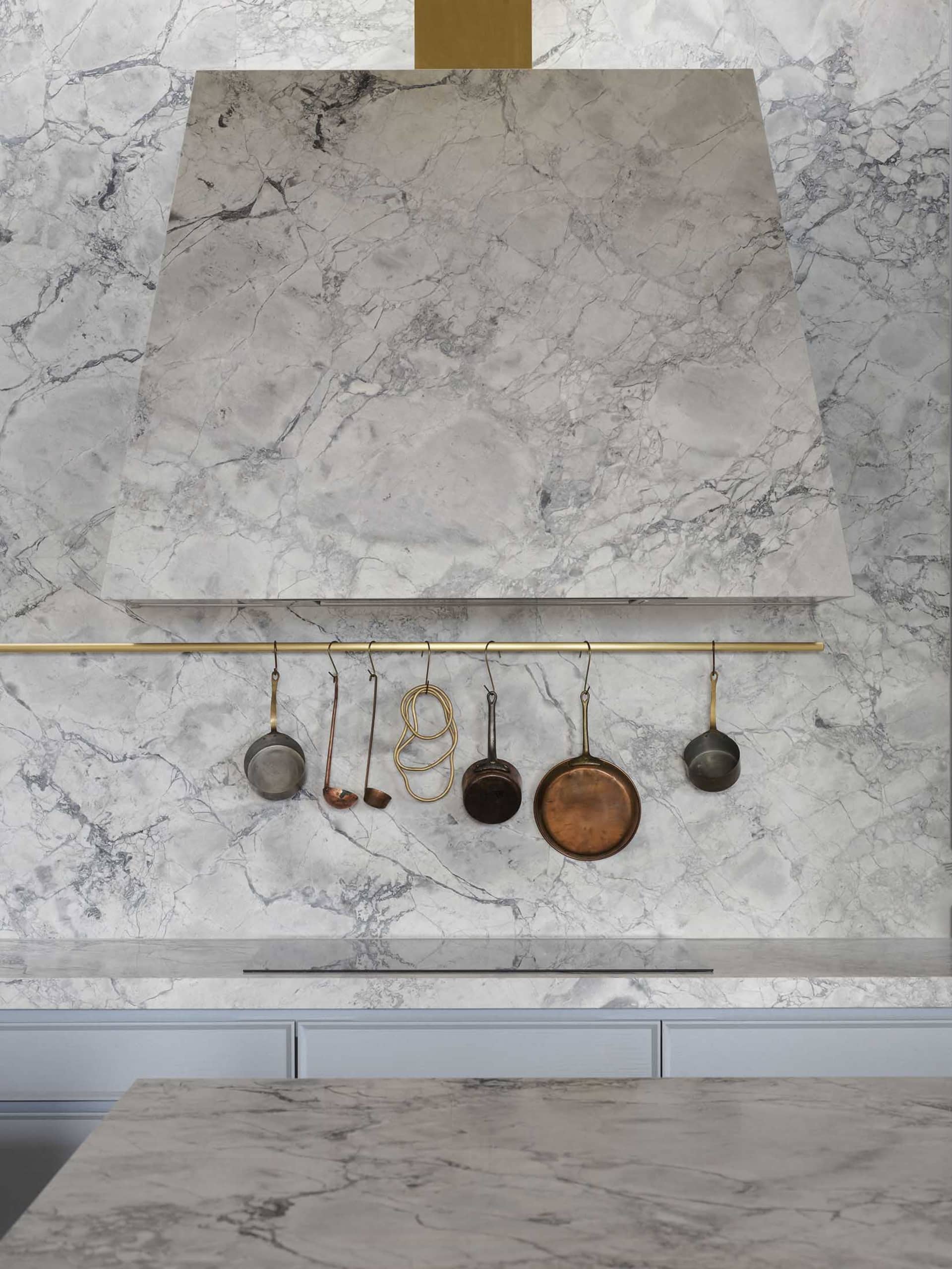 Modern kitchen featuring marble countertops and backsplash.