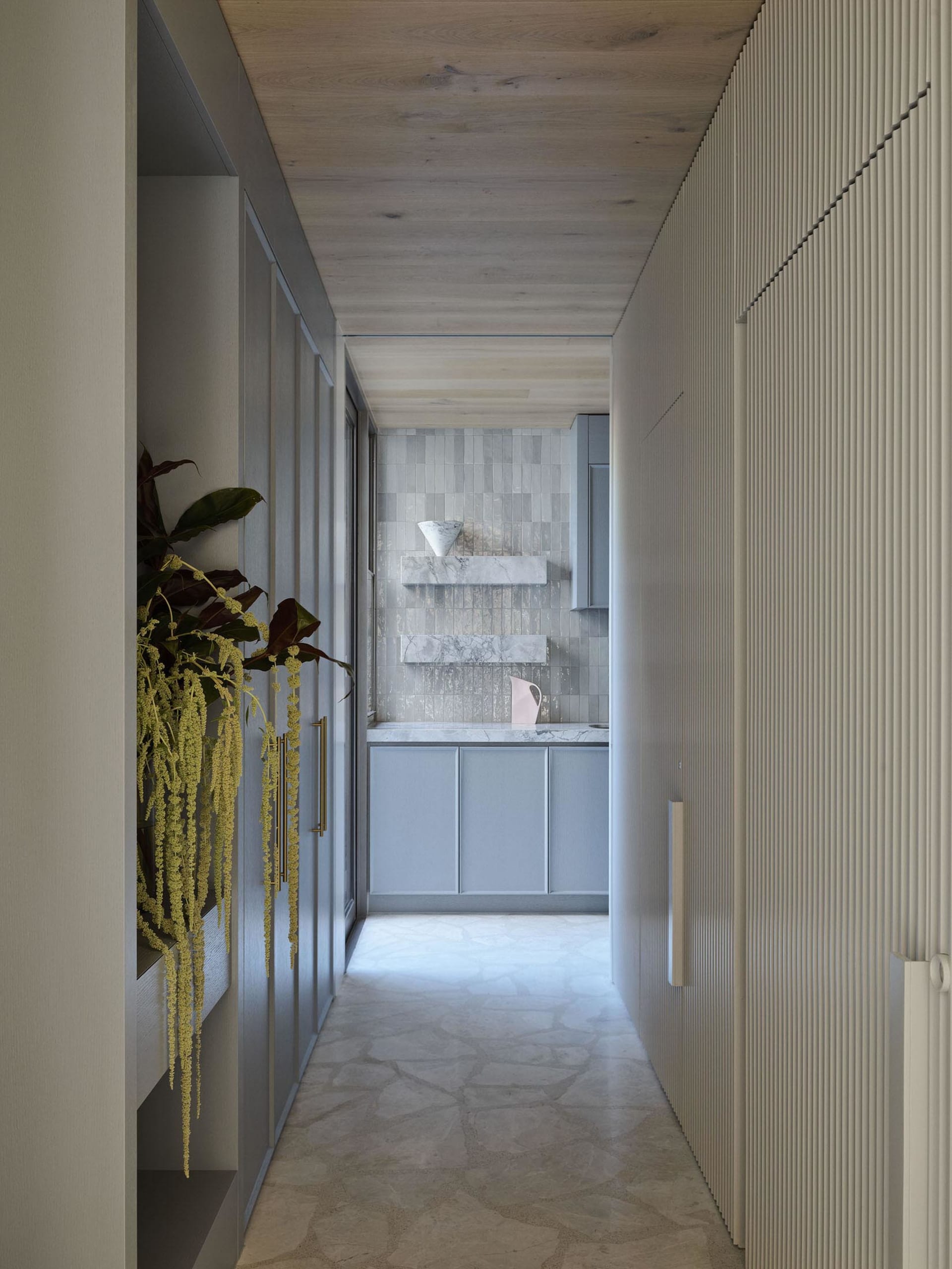 Modern kitchen featuring marble surfaces and white cabinetry, with a minimalist design.
