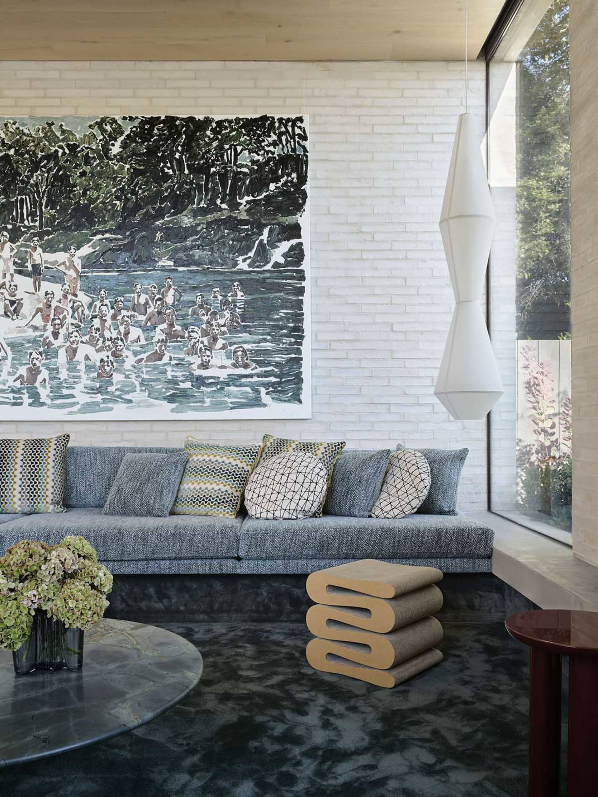 Modern interior design featuring a contemporary sectional sofa, abstract wall art, and geometric lighting fixture.