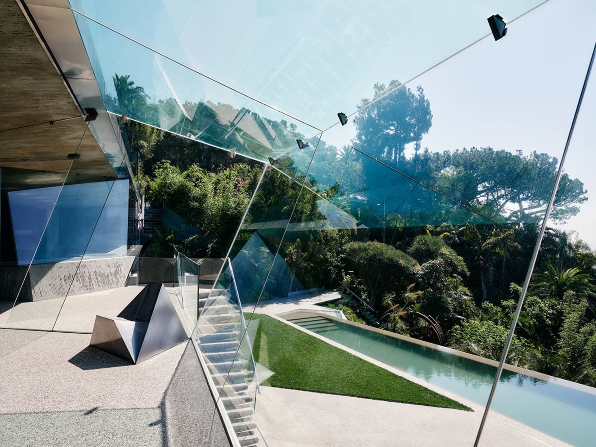 現代住宅以玻璃牆面與混凝土結構為特色,周圍環繞茂密綠意。