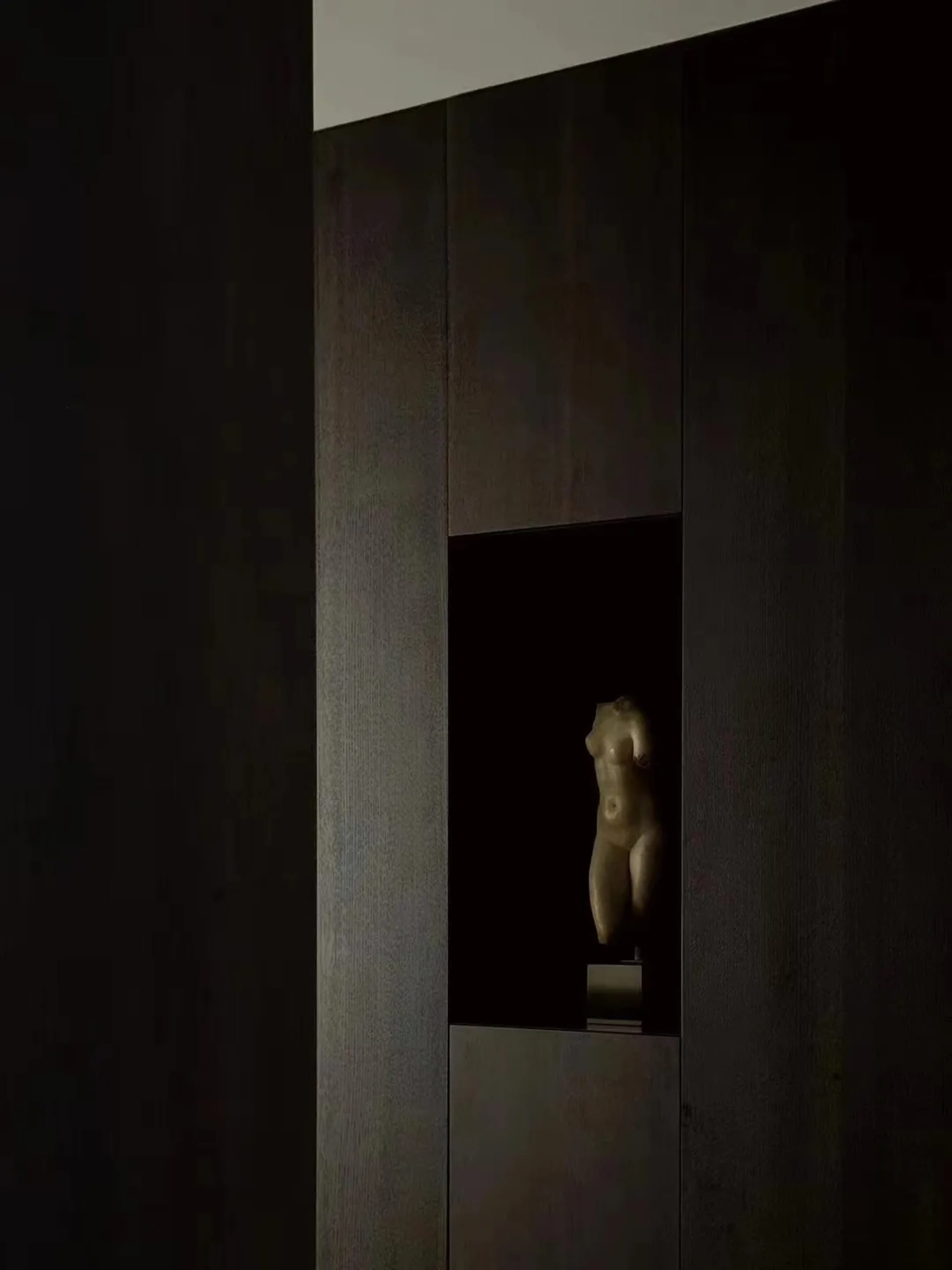 A carved wooden sculpture embedded in a dark wooden wall