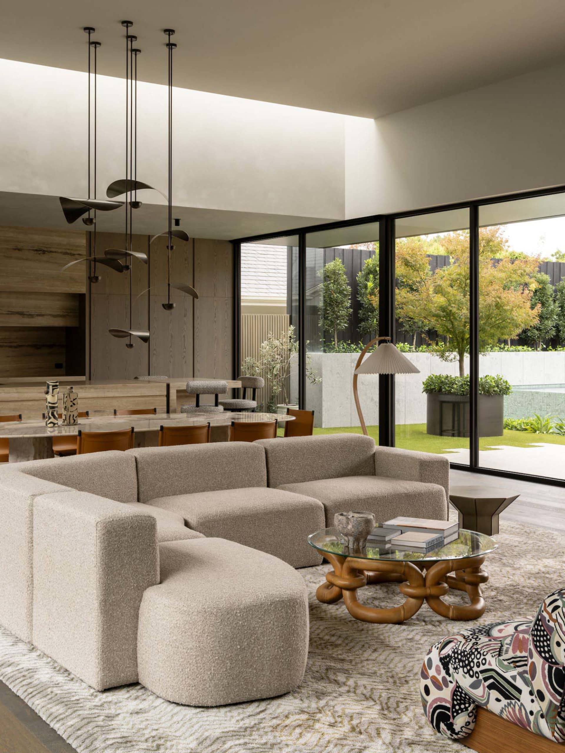 A modern living room featuring a large, textured fabric sofa and a round, wooden coffee table.