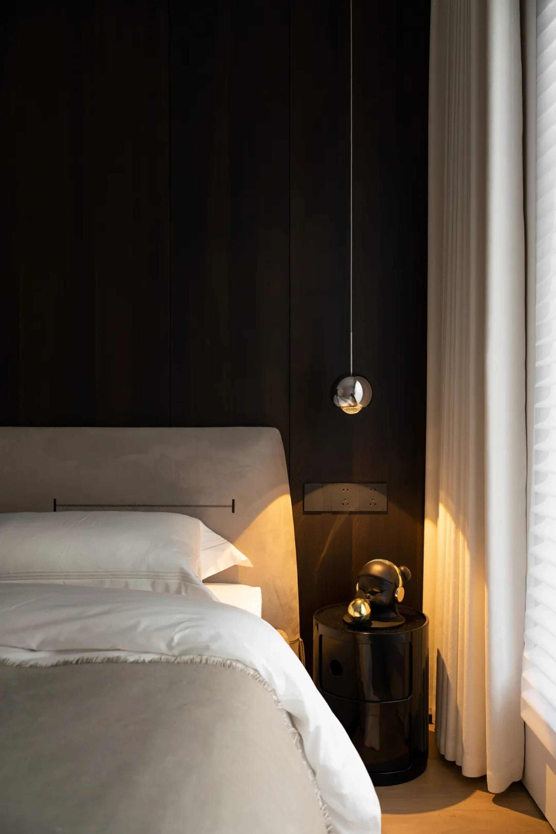 Minimalist bedroom featuring upholstered furniture and glass elements.