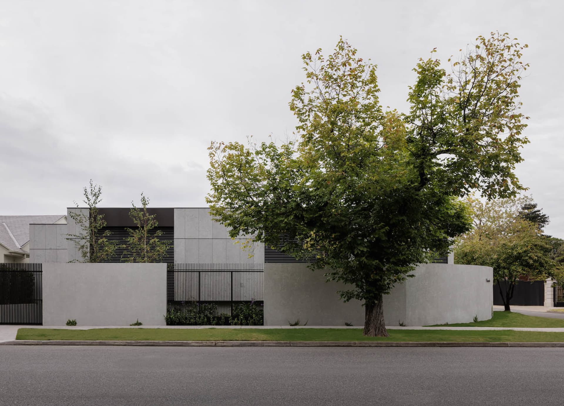 A modern residential exterior with a concrete facade and minimalist design.