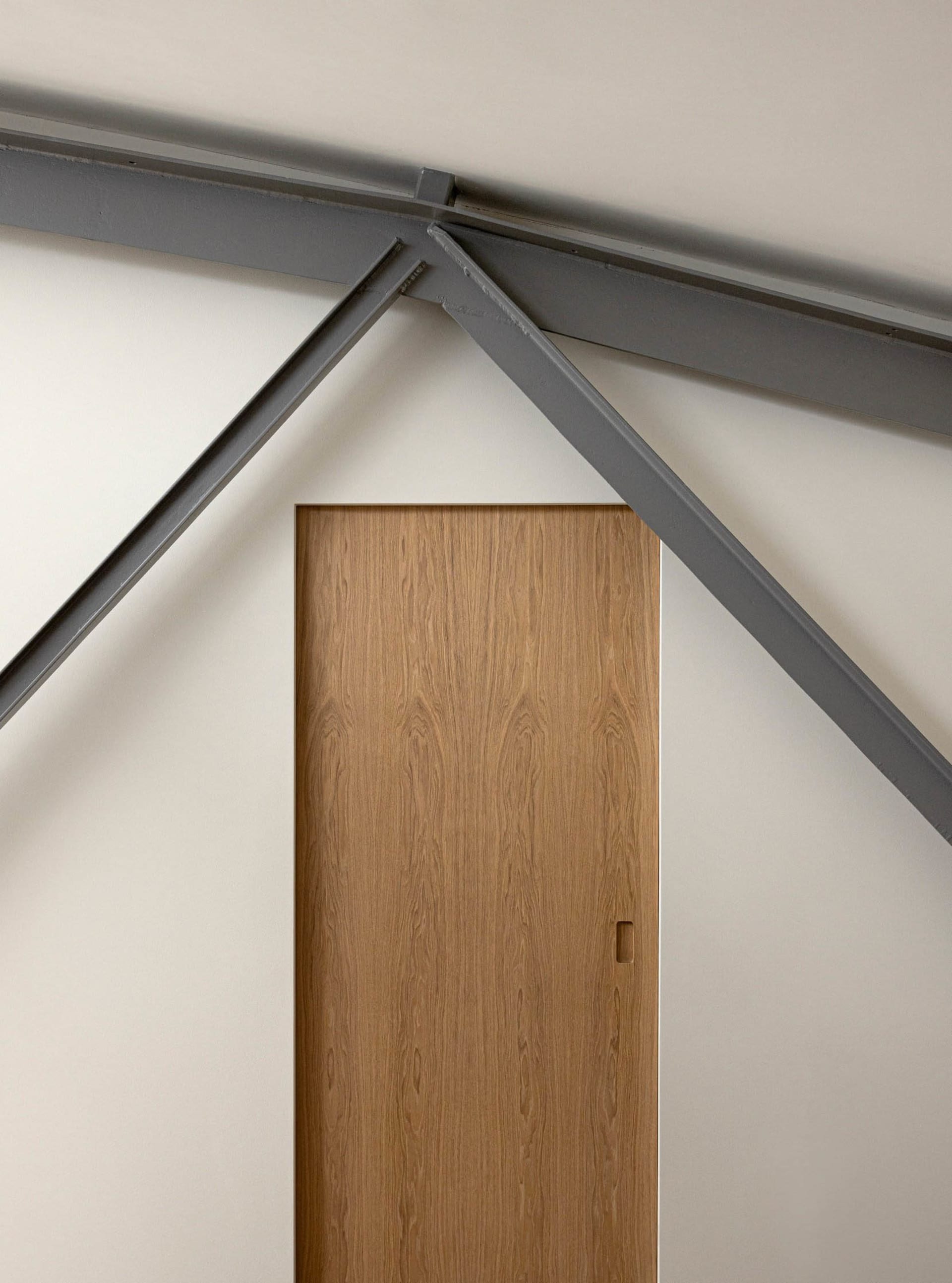 A modern, wooden door framed by steel beams.