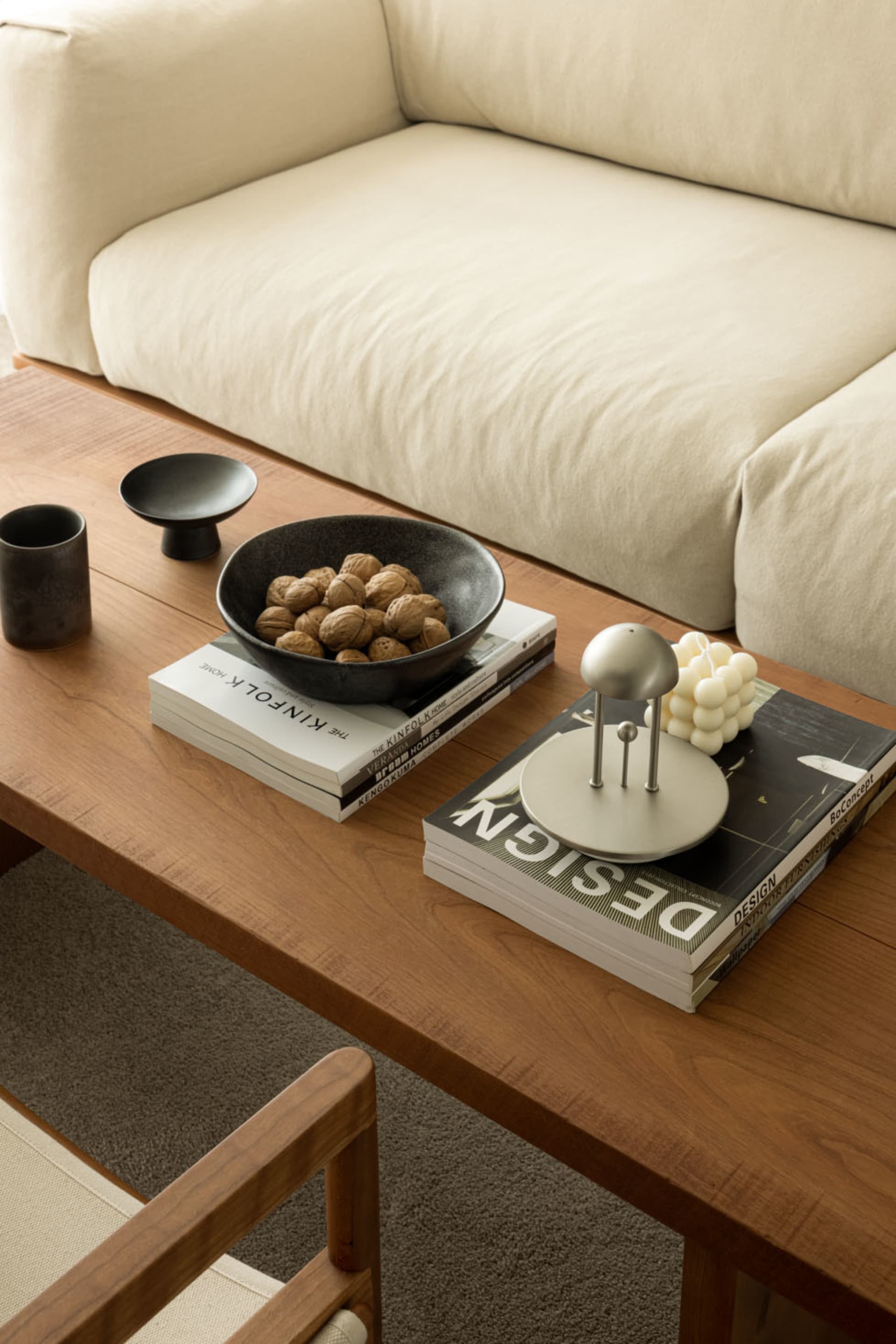 A modern living room featuring a wooden coffee table, ceramic objects, and comfortable cushions.