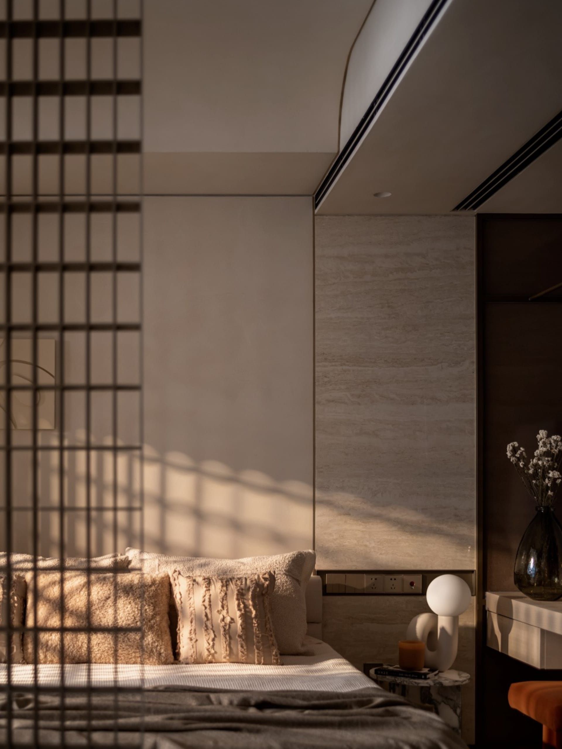 Modern bedroom with neutral-toned materials and cozy bedding.