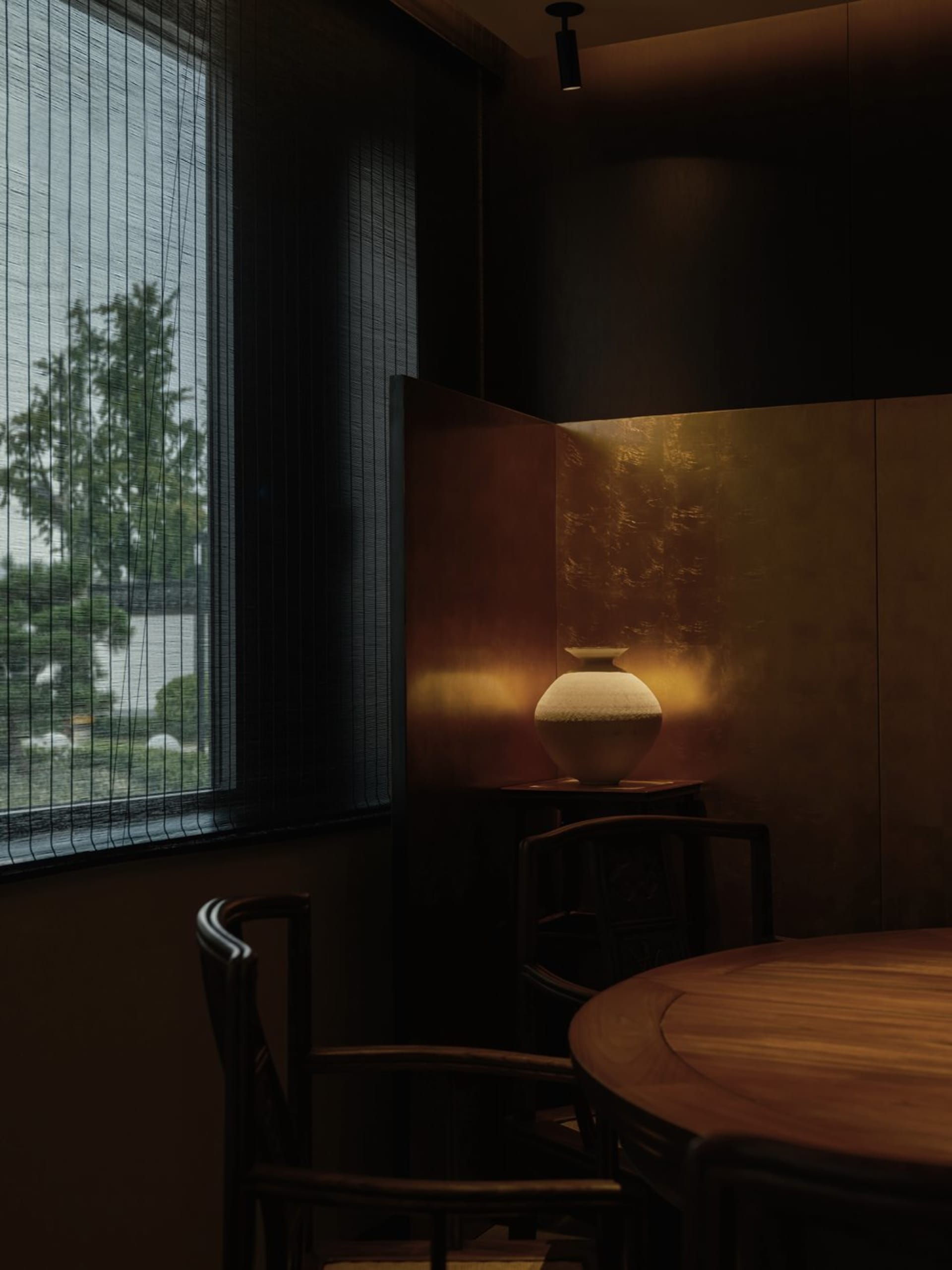 Modern dining room featuring a ceramic vase on a table.