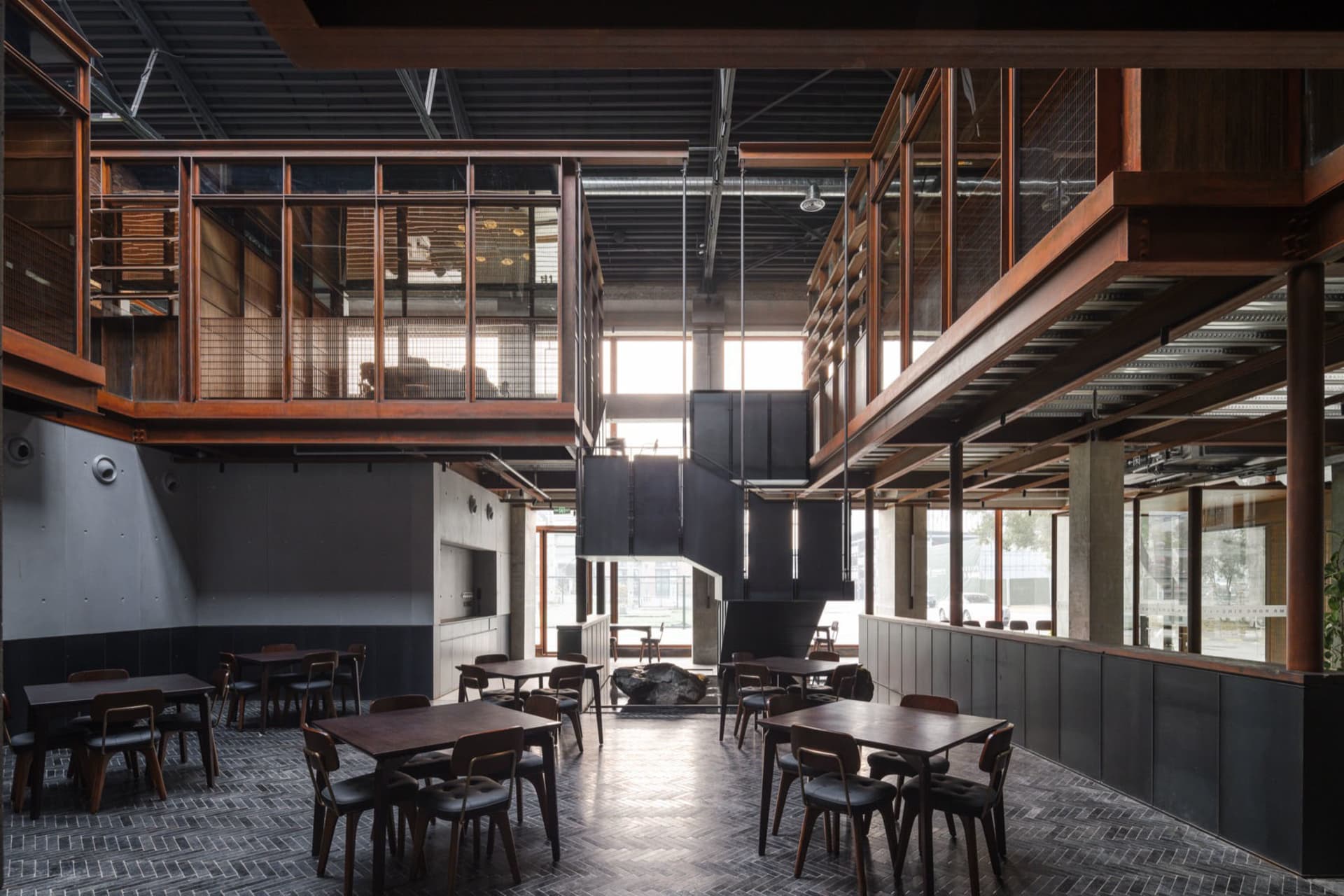 A modern restaurant interior featuring industrial elements such as wood, metal, and glass.