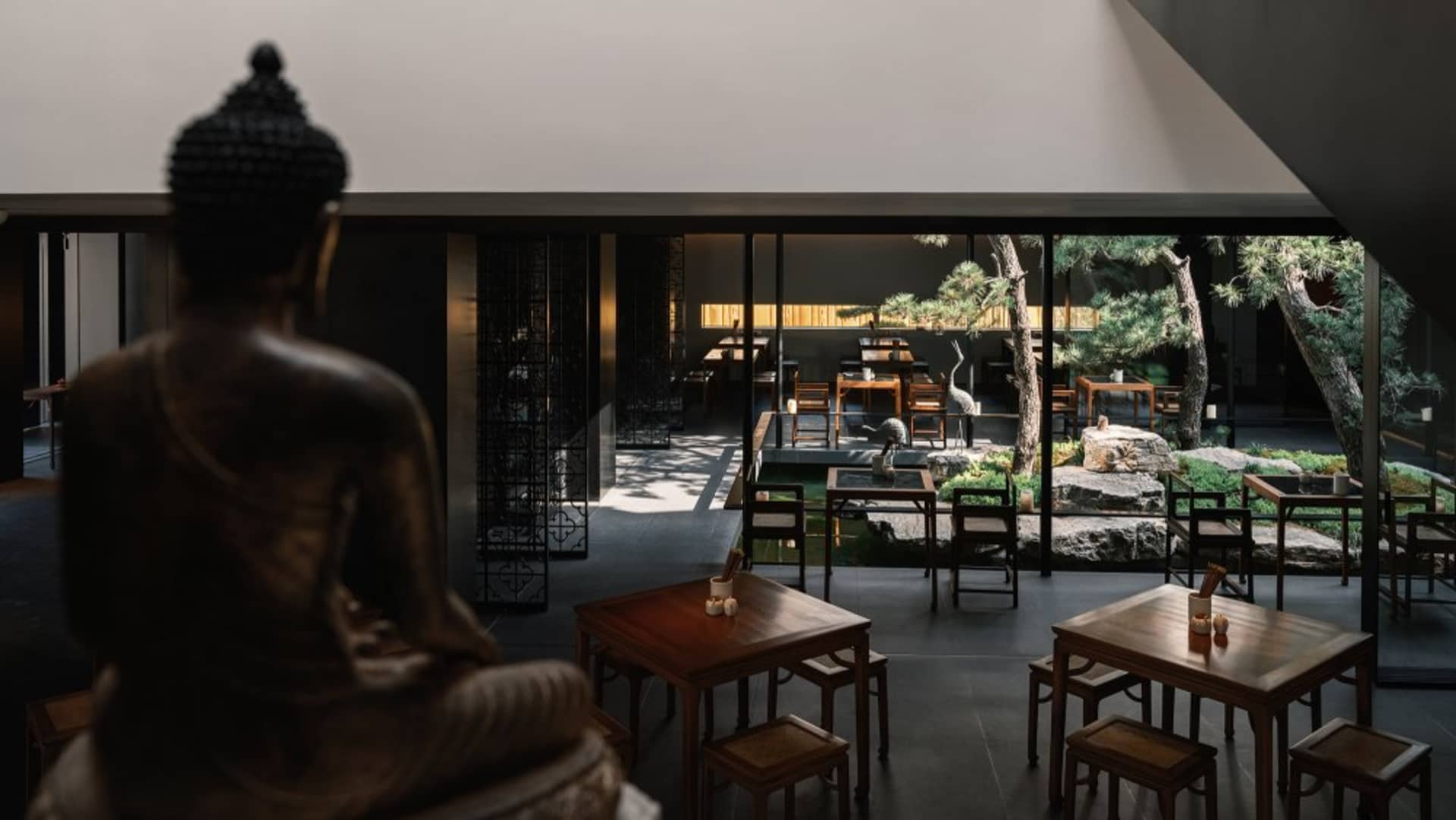 現代簡約餐廳室內,搭配木質家具與寧靜的戶外中庭。