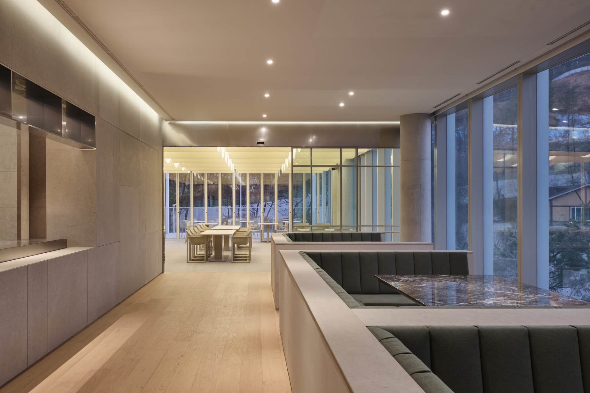 A modern interior design featuring concrete, glass, and marble materials in a coffee shop setting.