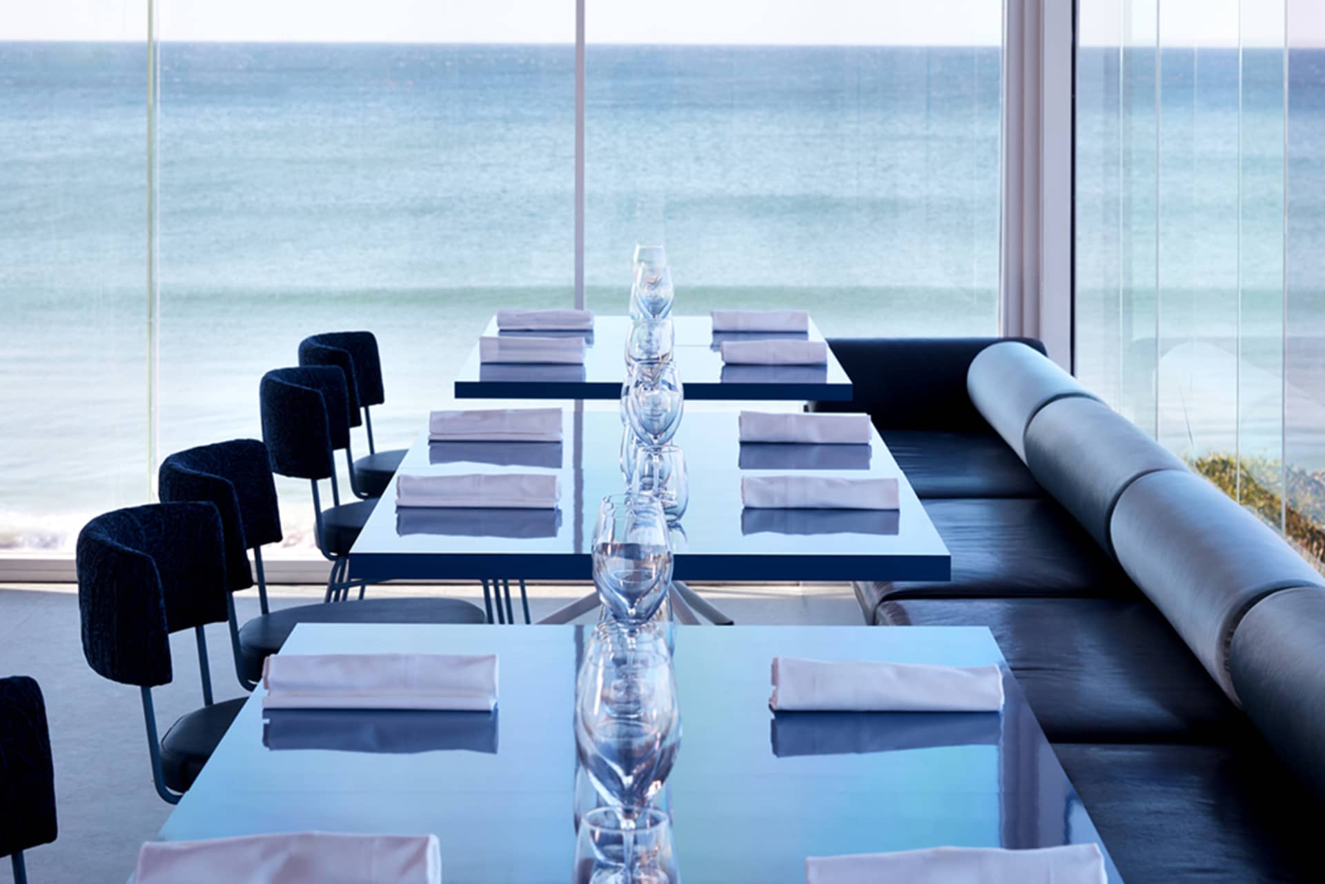Modern table setting with glassware and folded napkins in a coastal restaurant setting