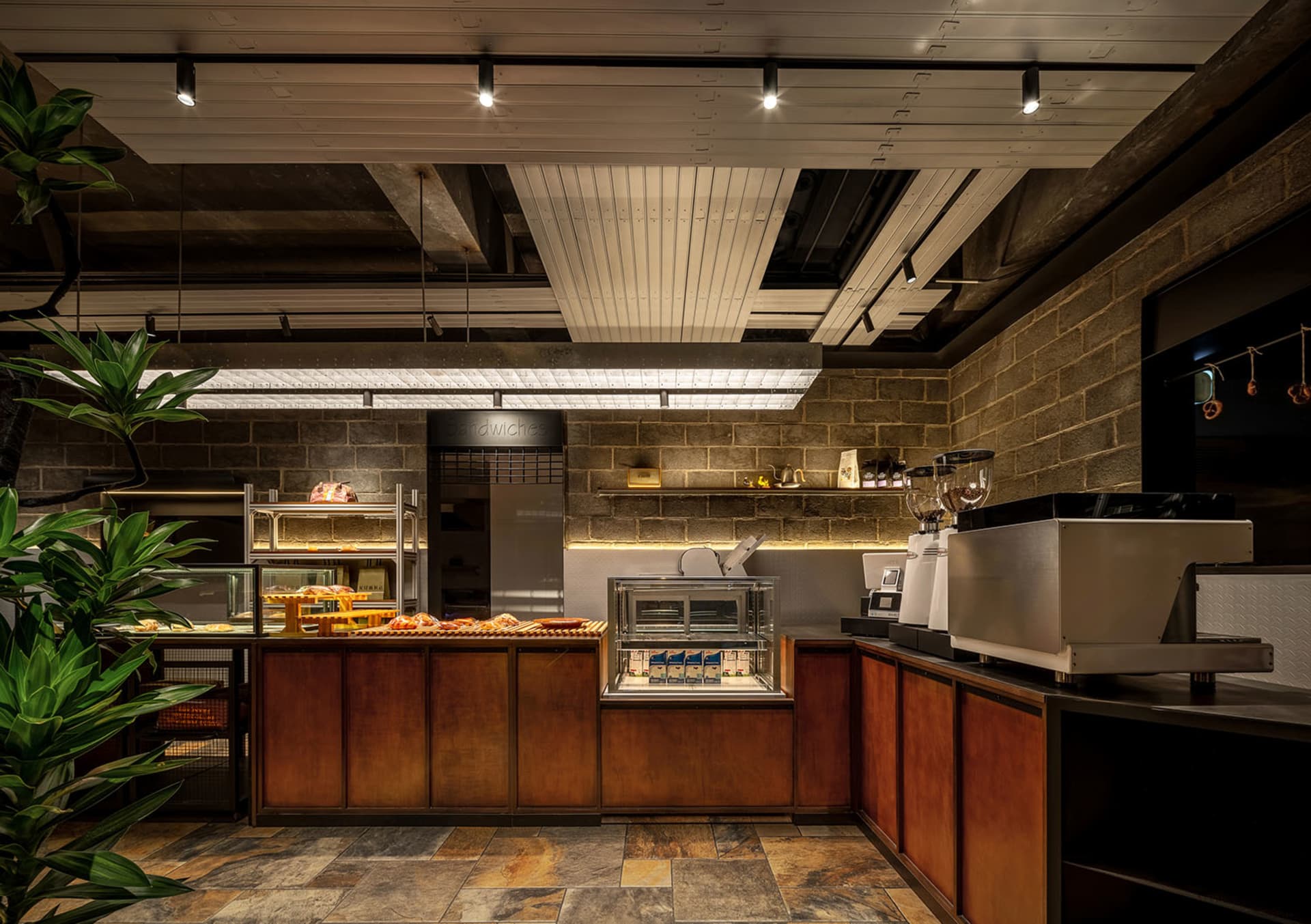 A modern industrial-style coffee shop with concrete, wooden, and glass materials.