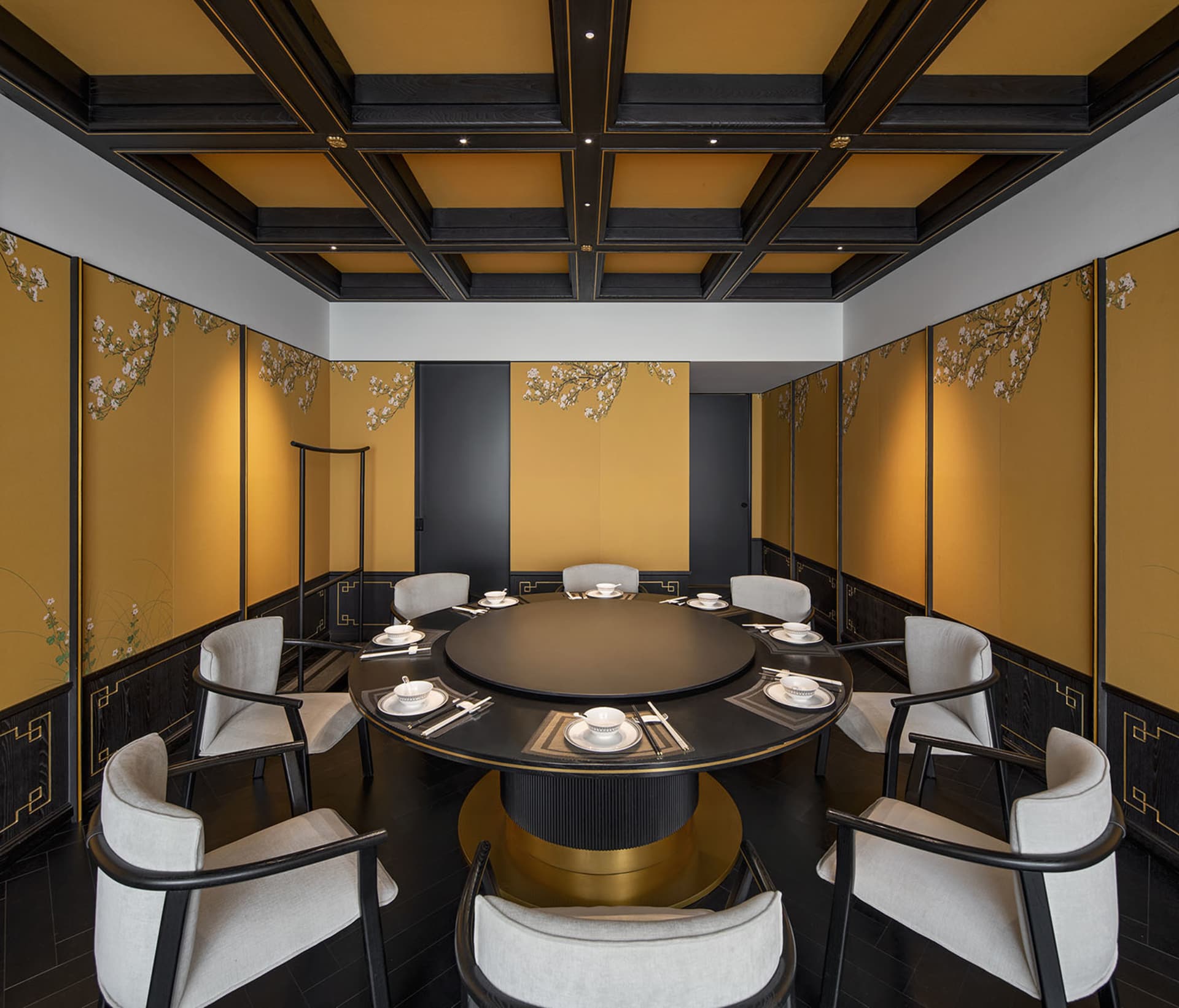 A modern, industrial-themed restaurant interior featuring a metal frame and round dining table surrounded by white upholstere
