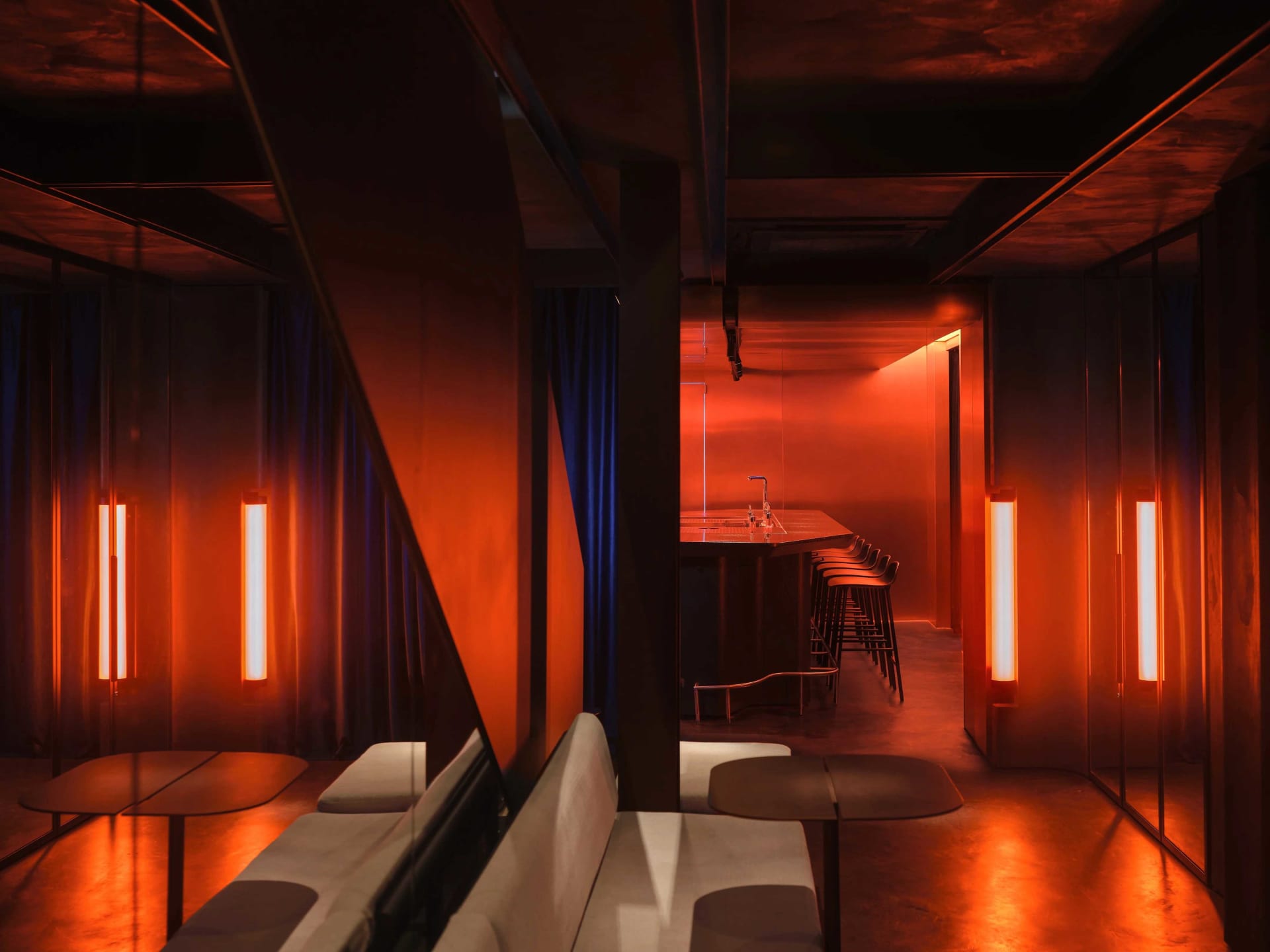 Modern industrial bar interior with metal accents and dim lighting.
