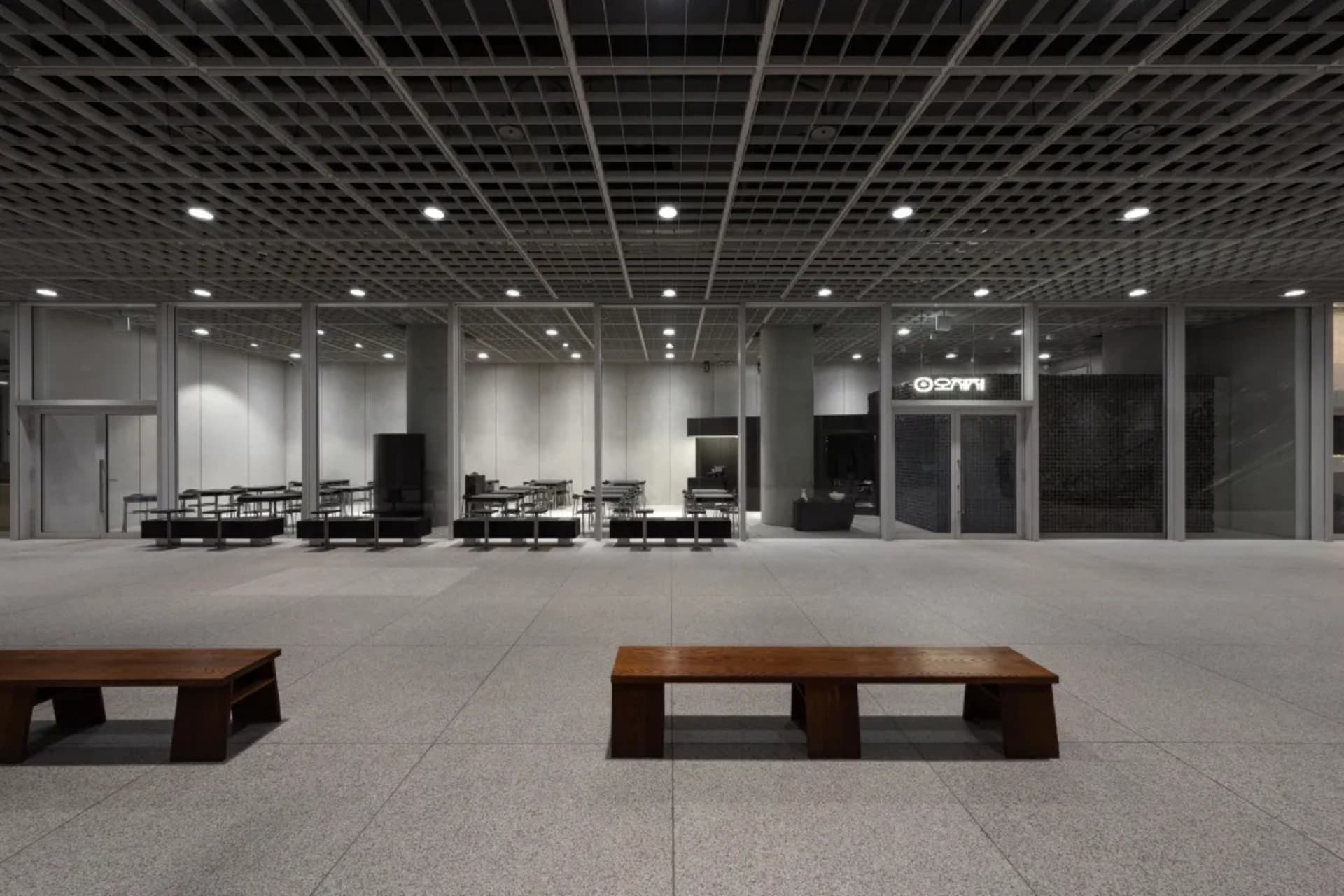 A spacious, modern office interior featuring exposed concrete and steel structural elements.