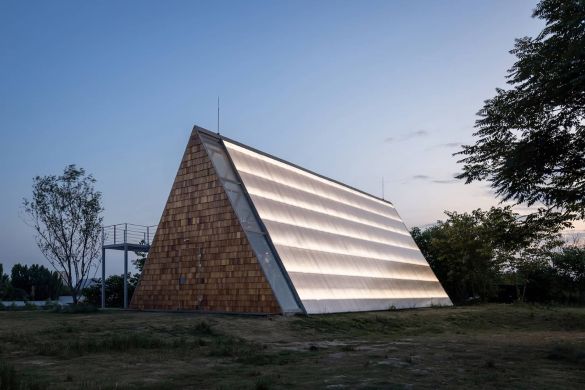 一座現代金字塔形建築，外牆採用木質材料搭配玻璃面板。