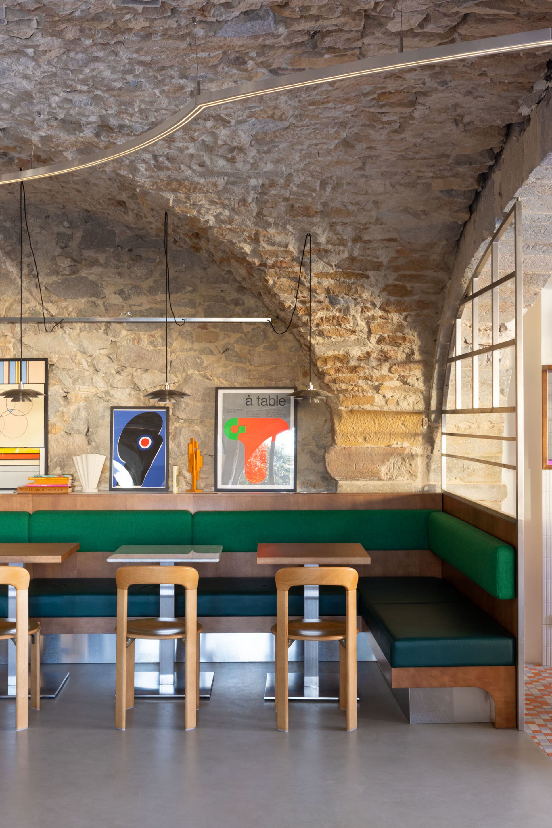 Modern restaurant interior with stone walls and contemporary seating.