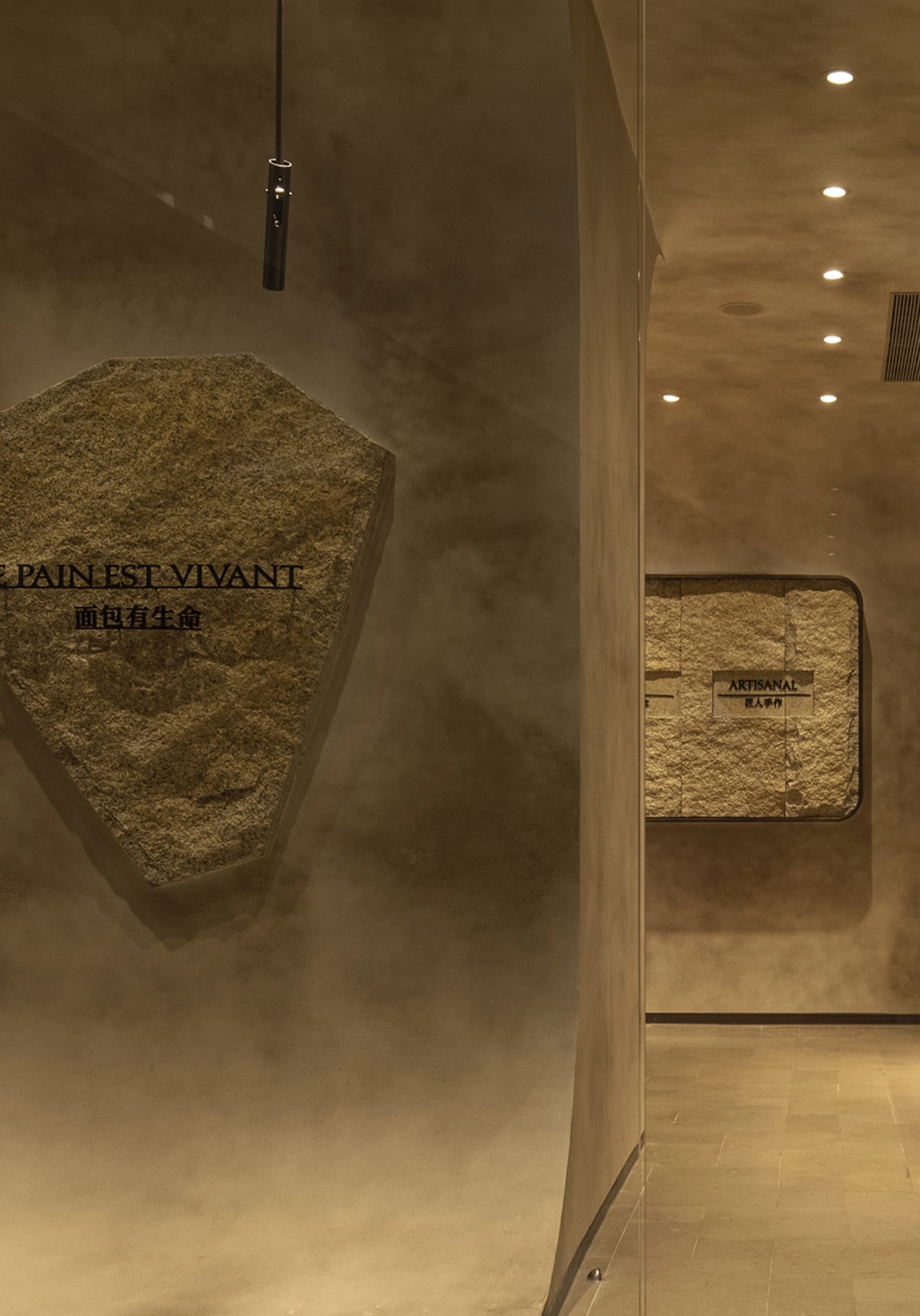 A modern storefront with a stone display window showcasing artisanal cookies.