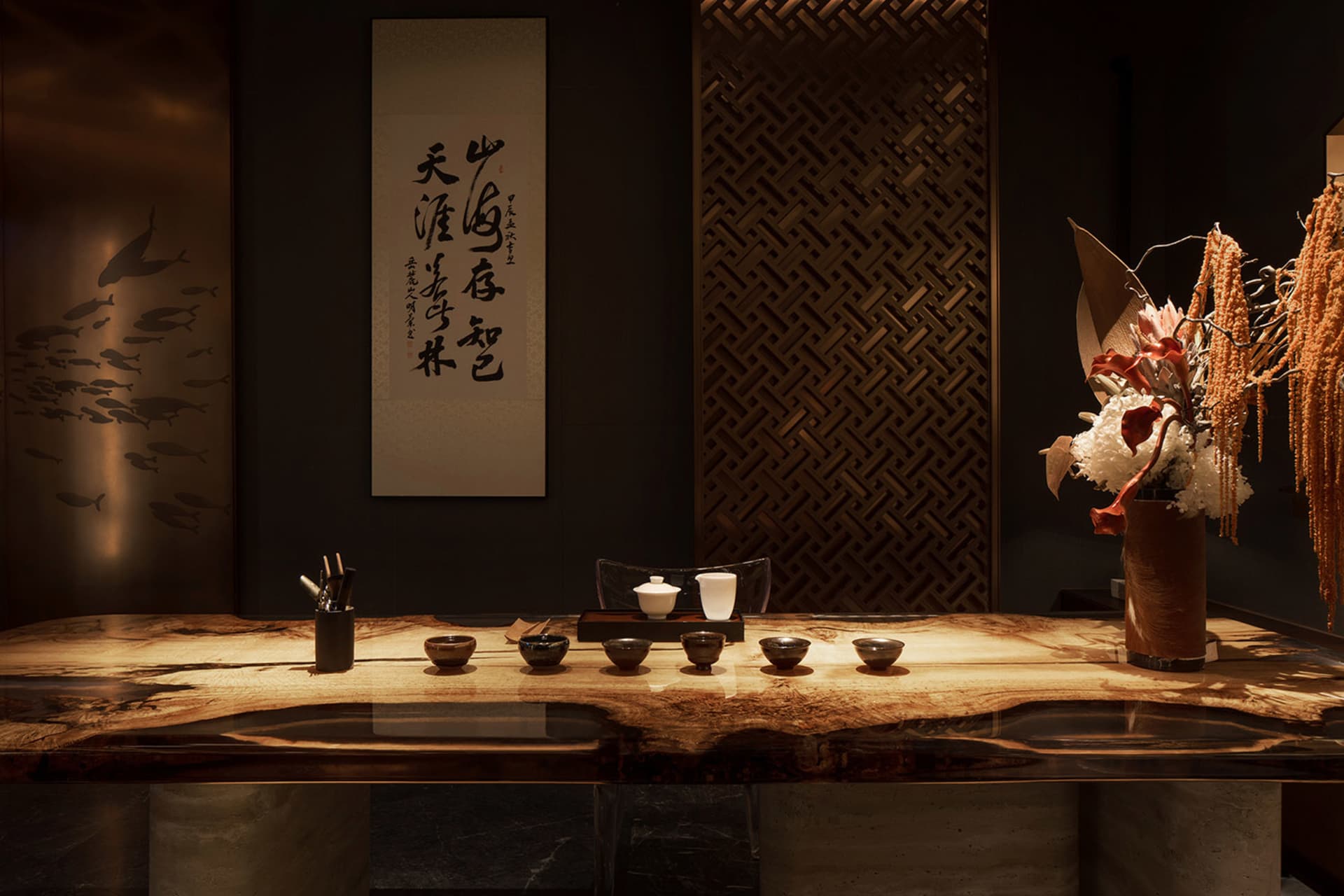 A sleek wooden counter with tea cups and utensils in a modern tea room setting.