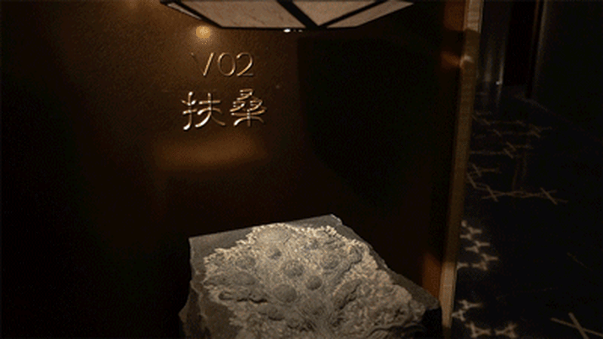 Modern stone lobby entrance with number 702 and Japanese characters