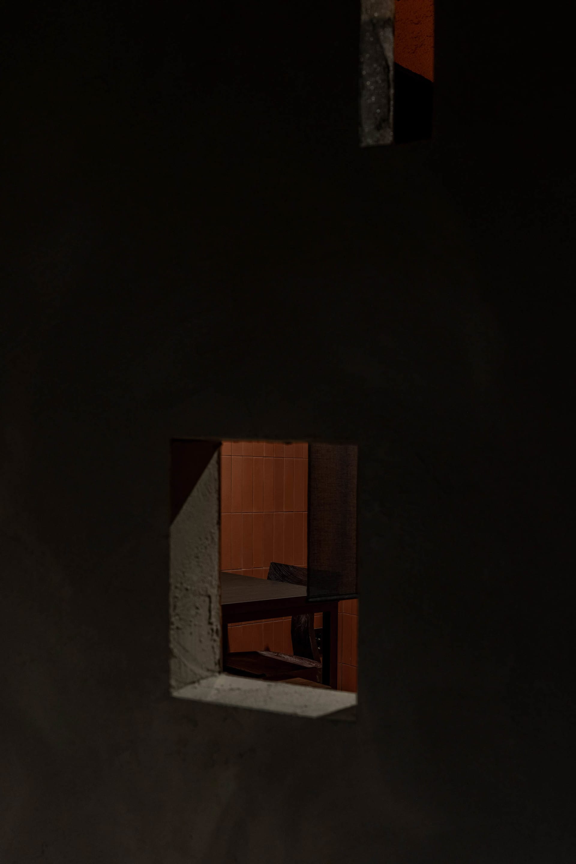 A minimalist interior space with a concrete wall and floor