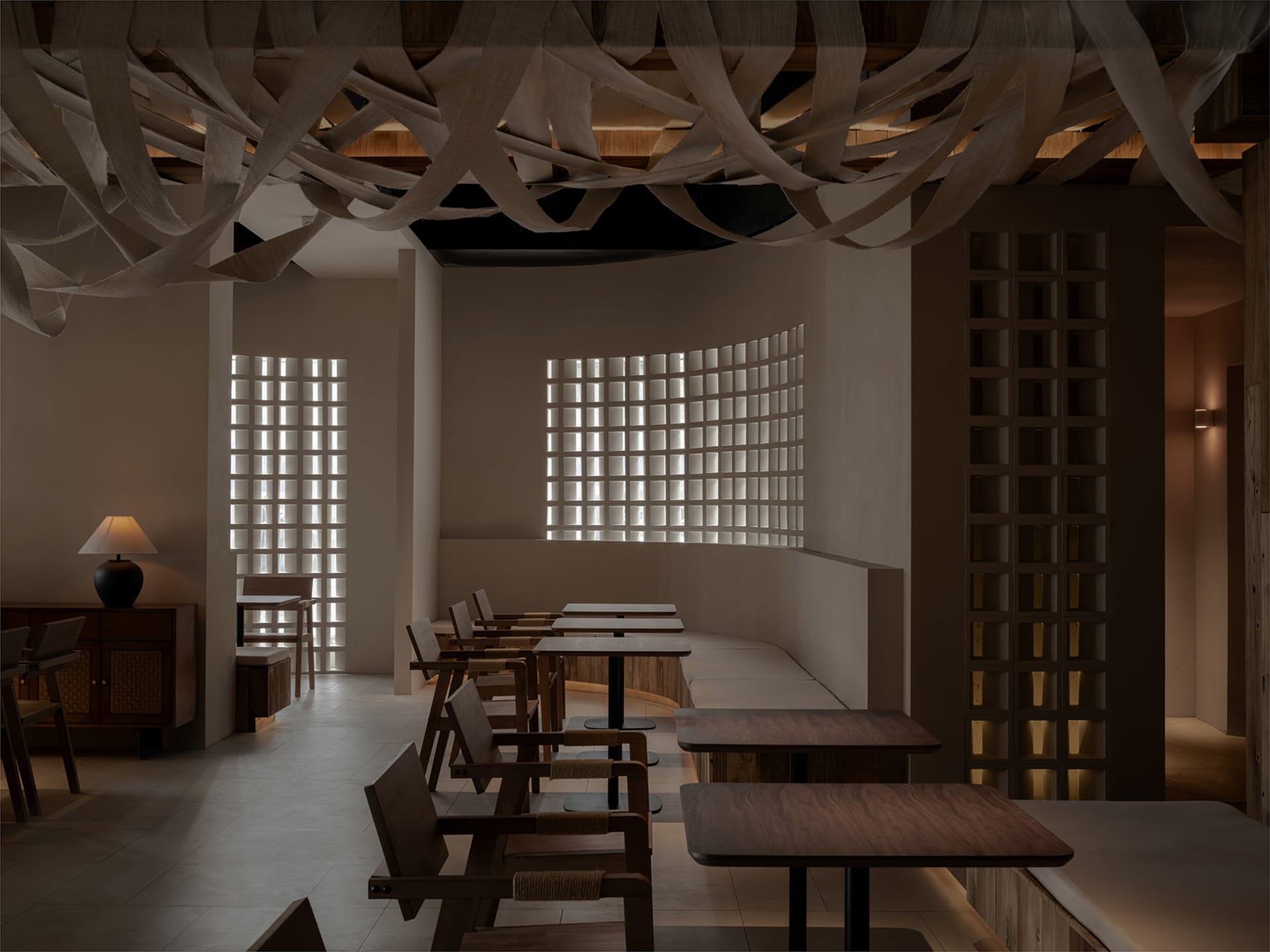 A cafe interior featuring wooden furniture and a grid-patterned window.