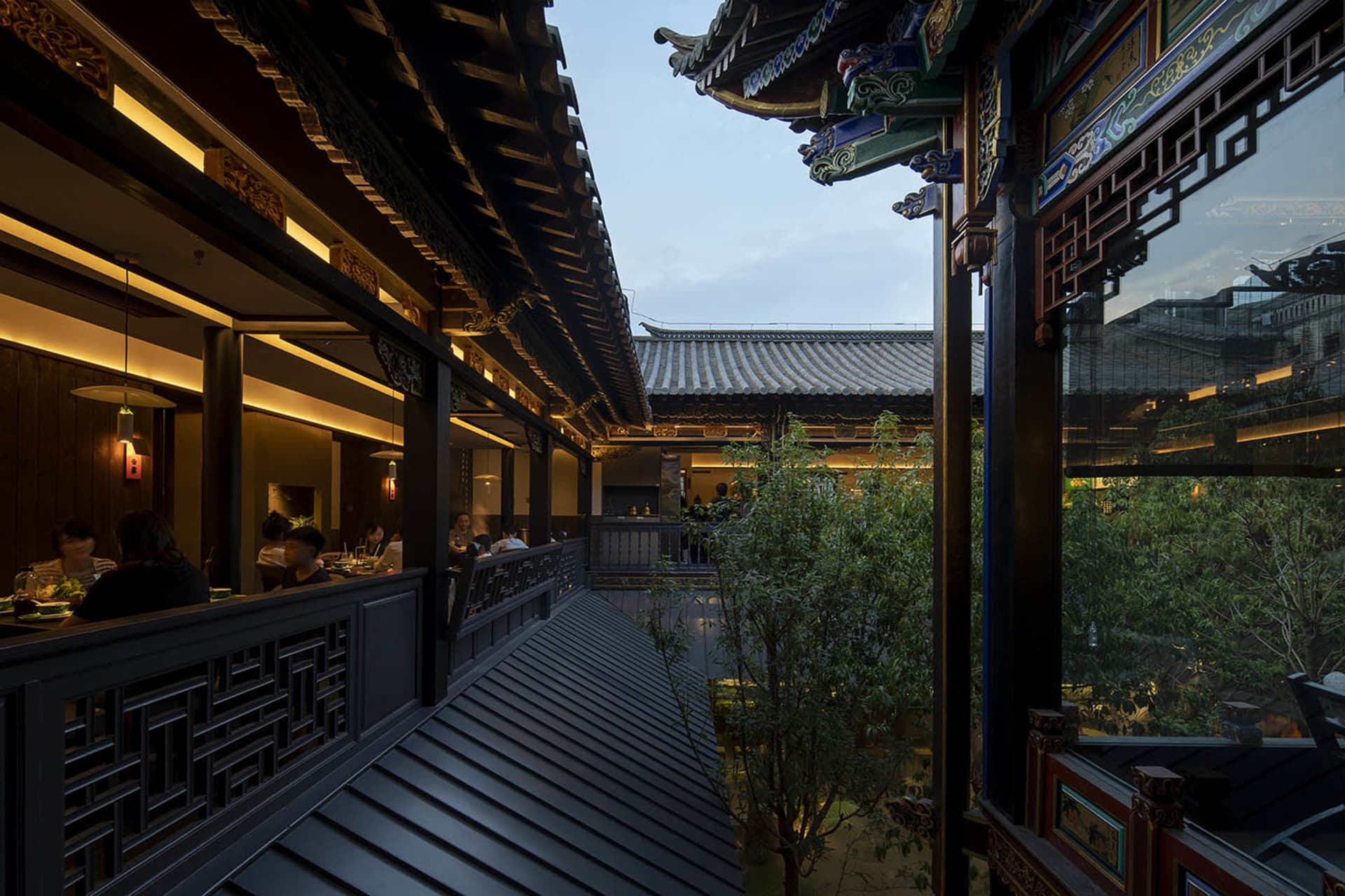 A photograph of a Chinese restaurant interior with wooden decorations and people dining.