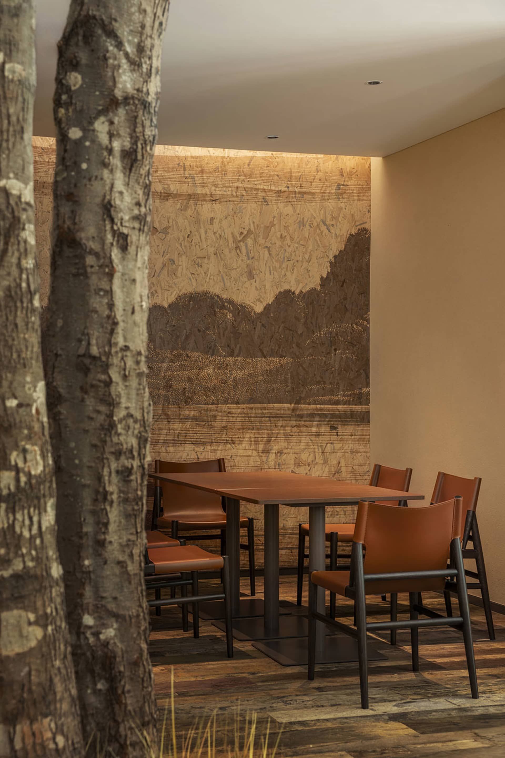 Industrially styled restaurant dining area featuring wooden furniture and walls with exposed wood