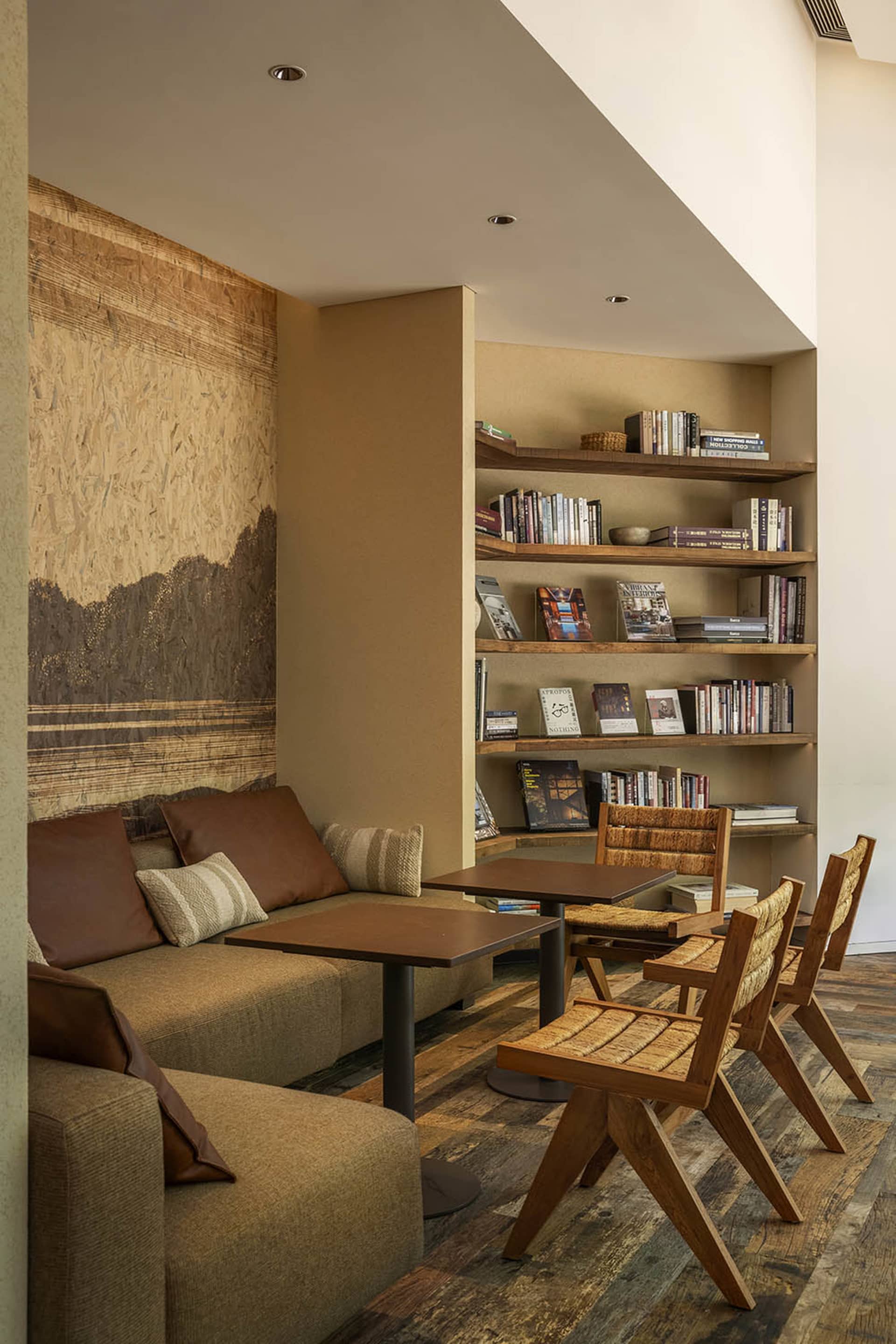 A living room with modern furniture, wooden bookshelves, and a cozy reading area.