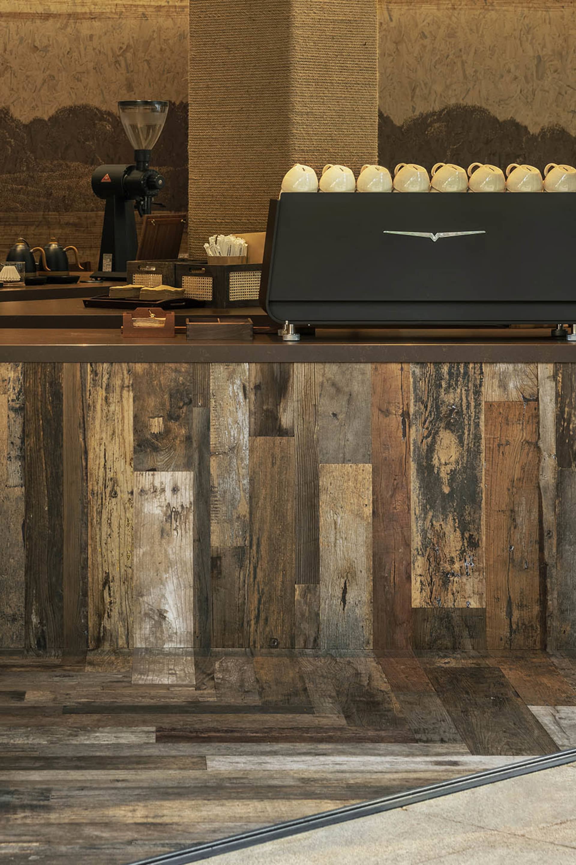 Industrial-style coffee bar featuring wooden materials and a sleek, modern espresso machine.