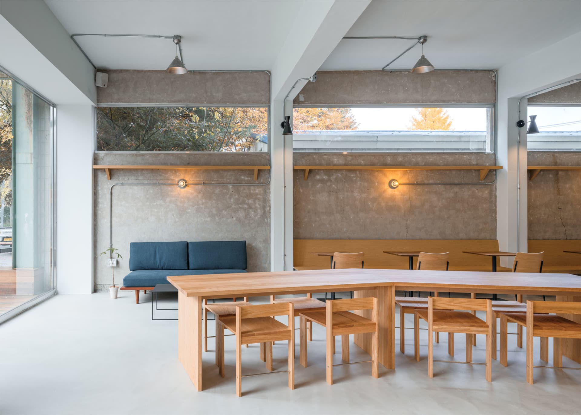 Modern cafe interior with wooden tables and concrete walls
