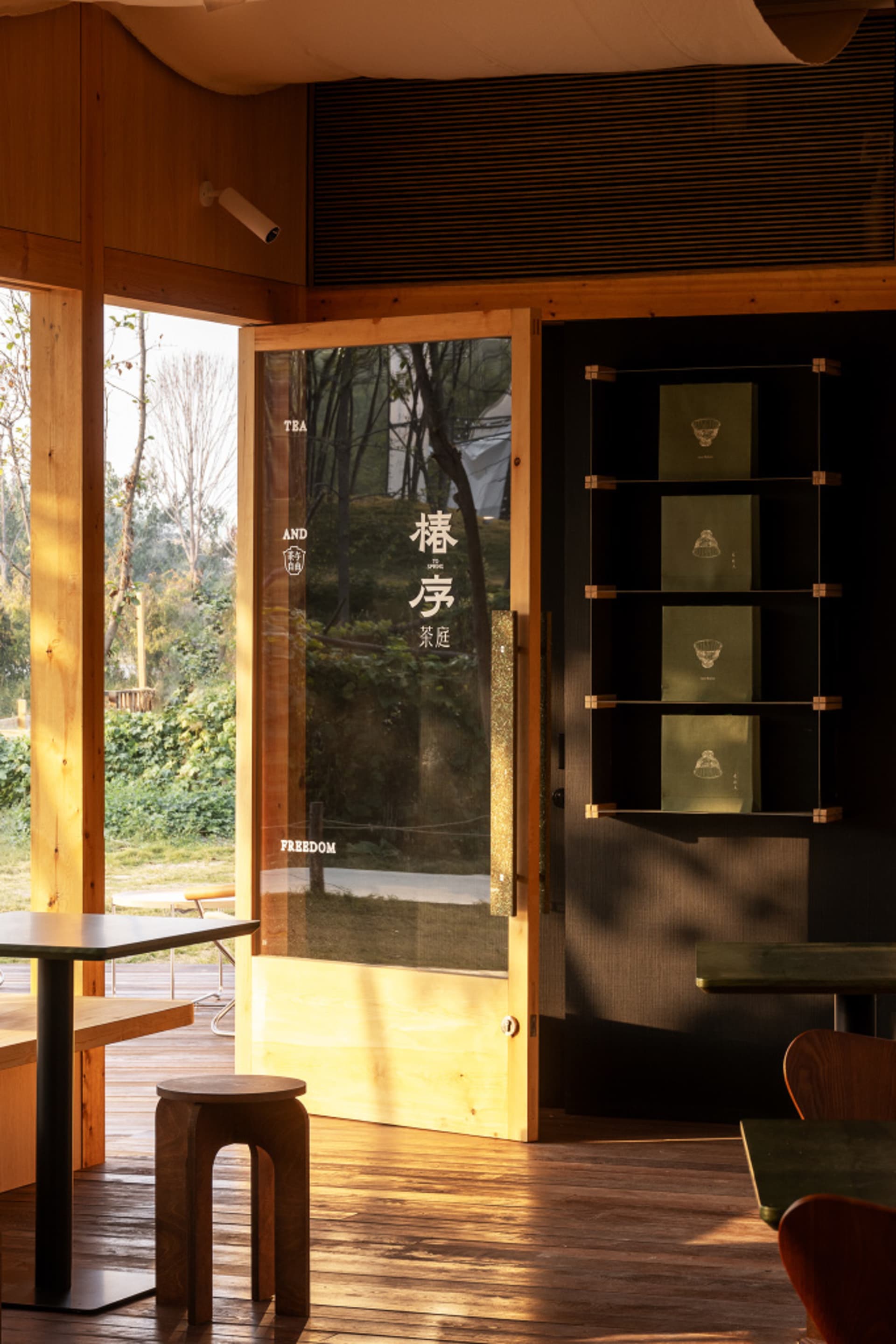 A modern coffee shop with wooden interior and glass door.