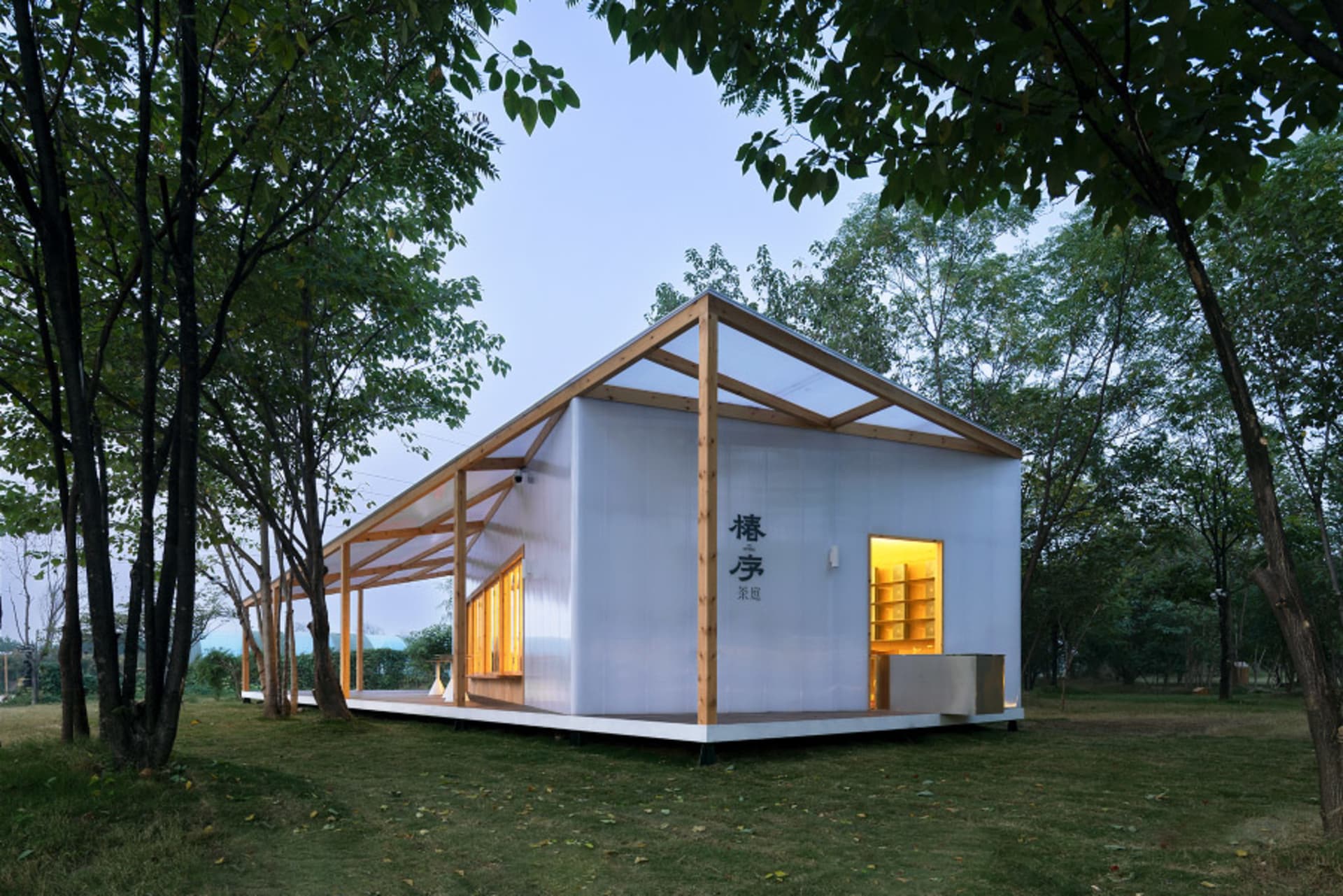 現代住宅金屬板與玻璃屋頂,坐落於綠意盎然的景觀中。