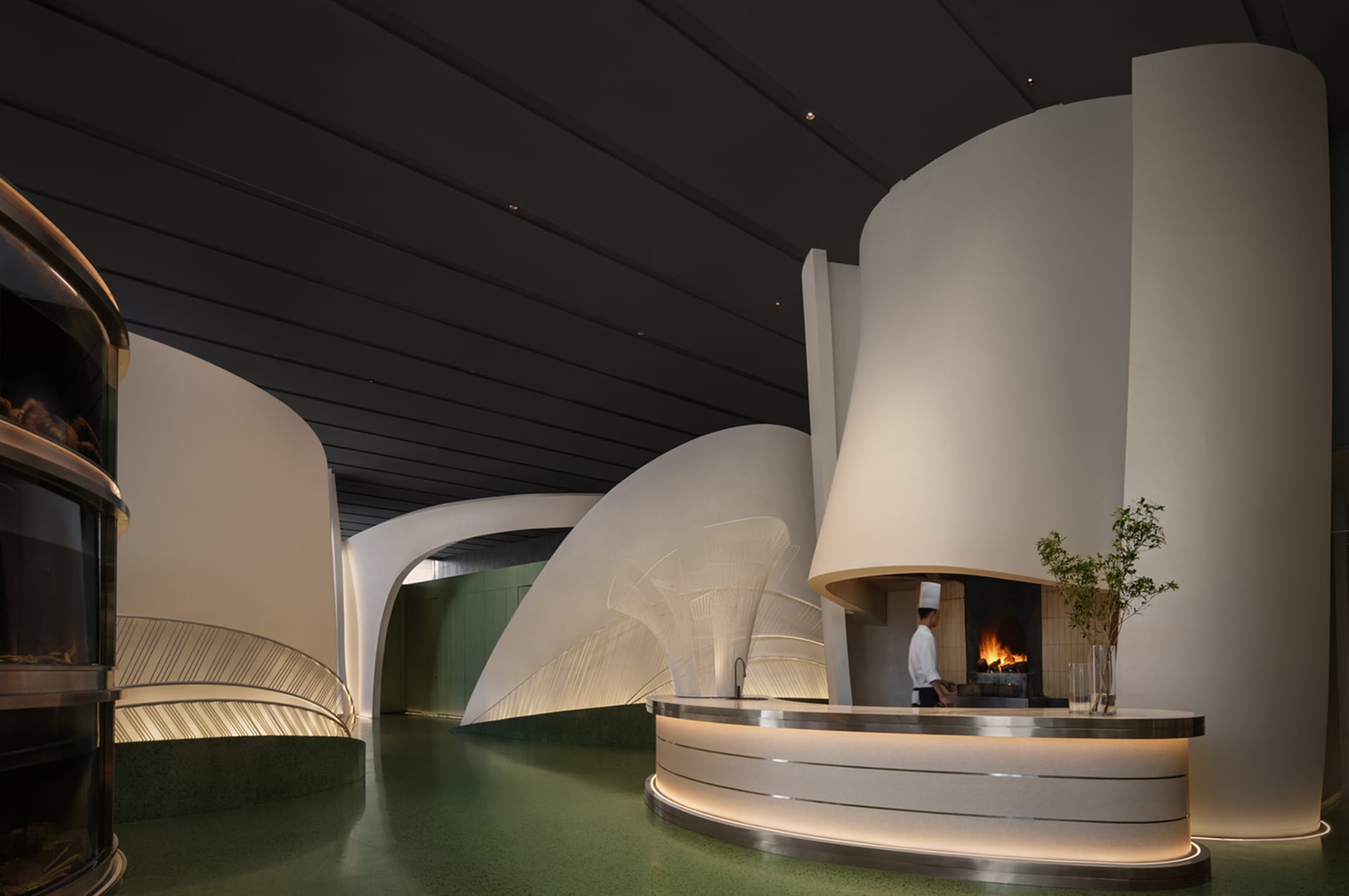 Circular white interior design features metallic surfaces and green flooring