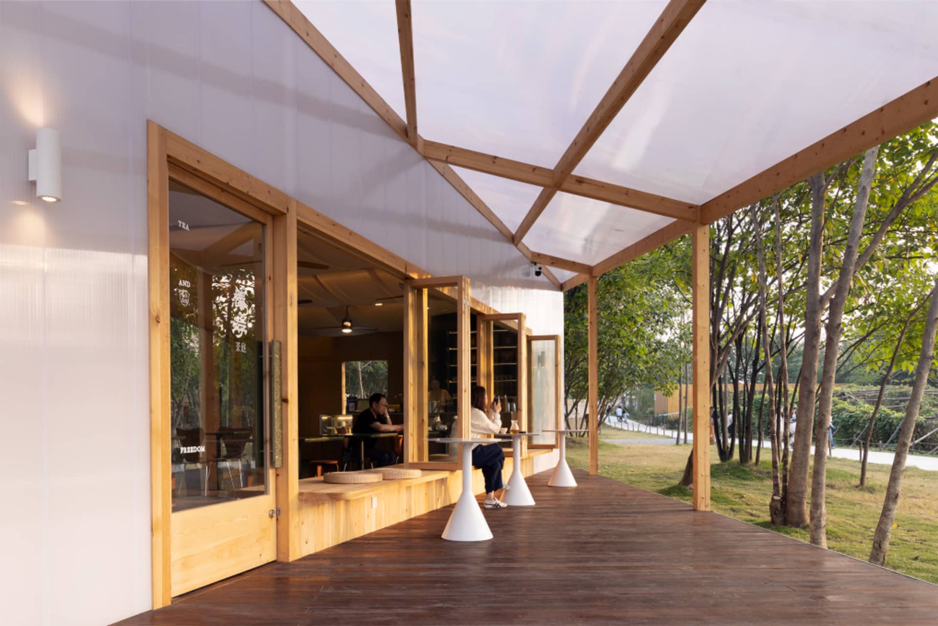 Restaurant exterior with modern pergola and transparent roof, designed with wooden elements.