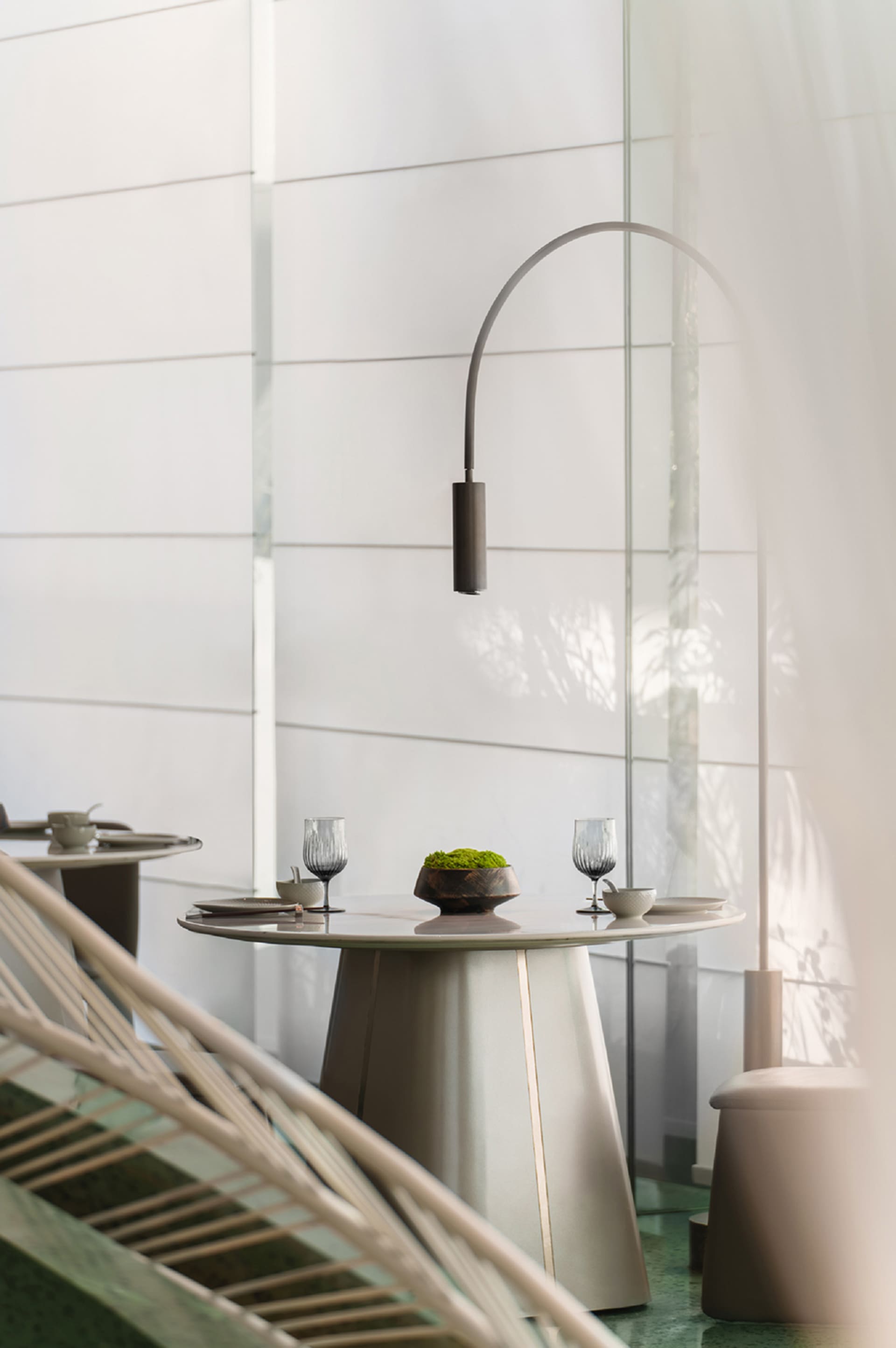 Modern dining room featuring a glass table with a metal base and minimalist decor.