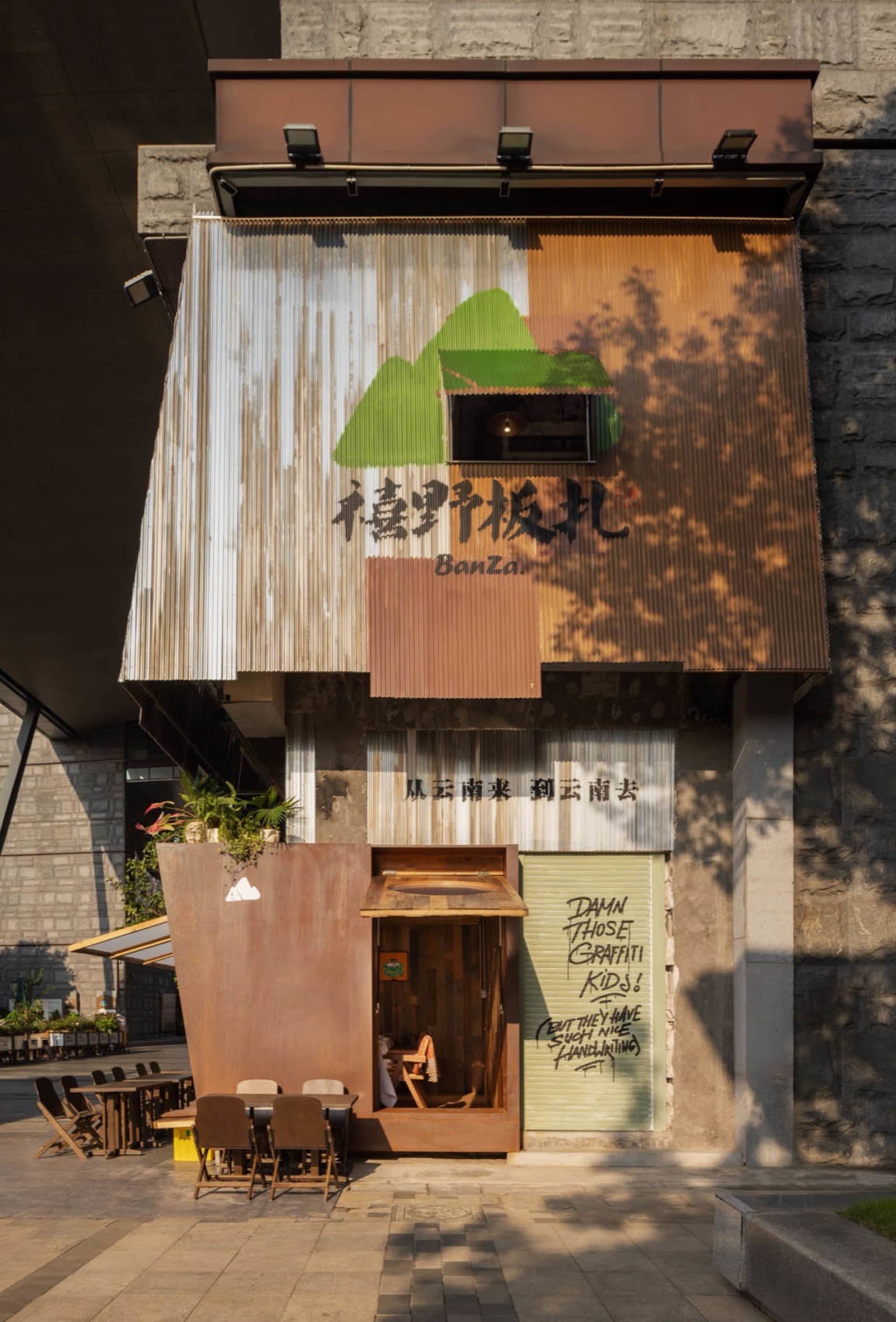 戶外用餐區設有金屬包覆遮篷與招牌，屬於市場小吃餐廳。