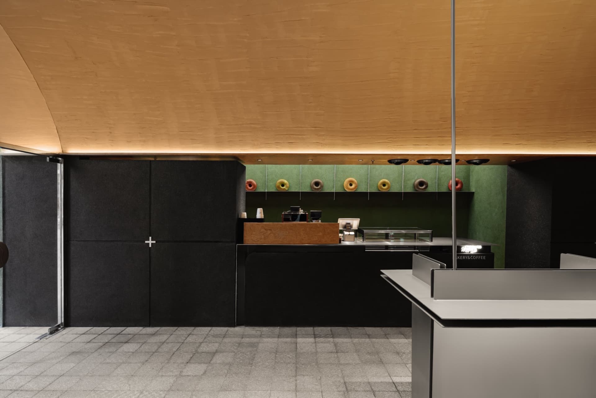 A minimalistic modern coffee shop featuring concrete and metal surfaces.