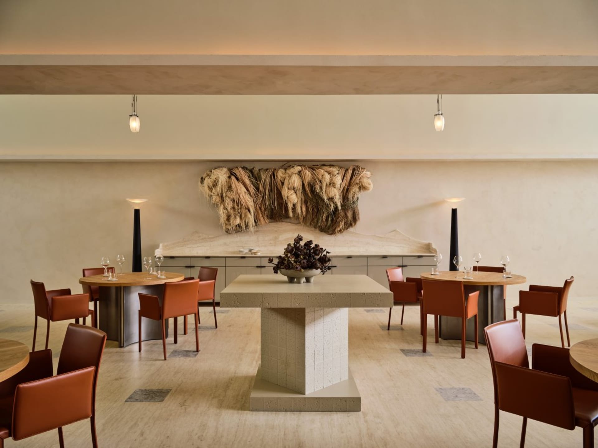 A modern restaurant interior with concrete accents and minimalist decor.