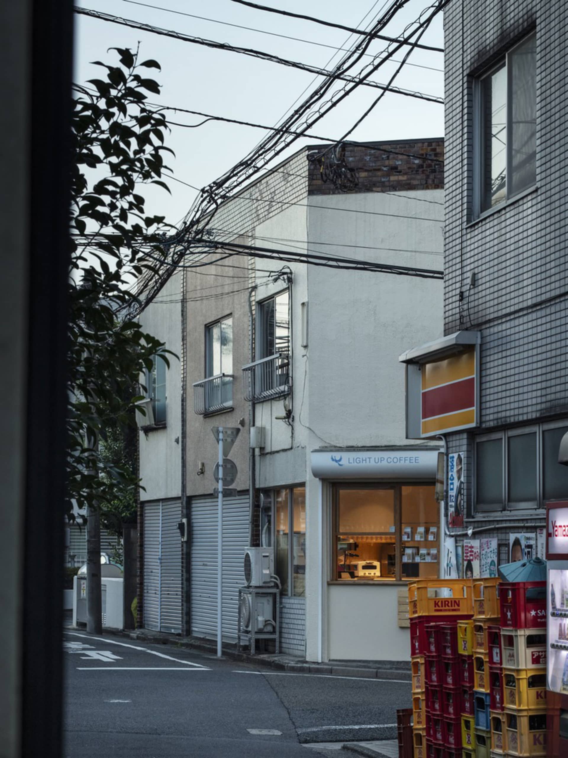 Electrical wires above a stone building in an urban street scene.