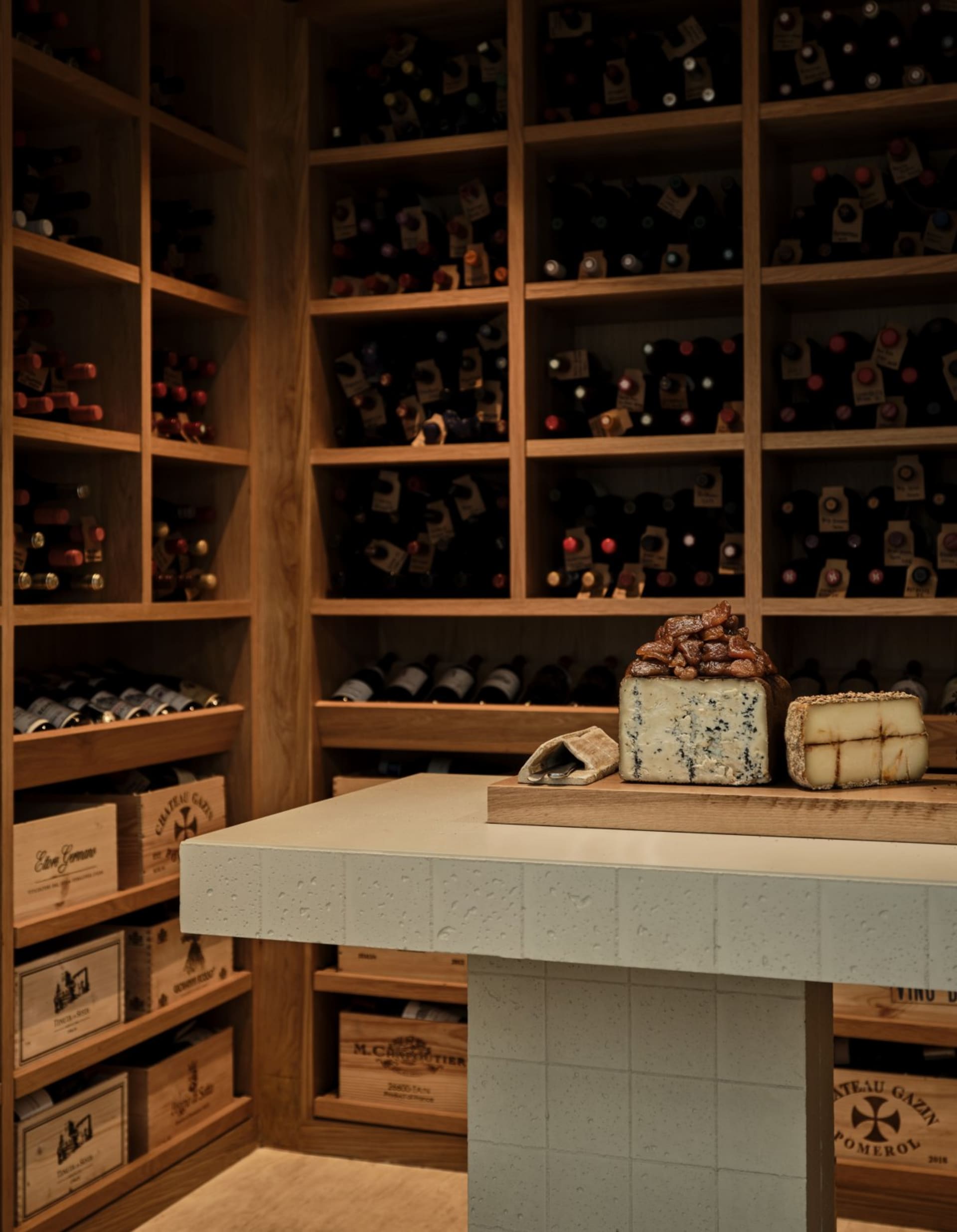 A well-stocked, industrial-style wine cellar with wooden shelves.
