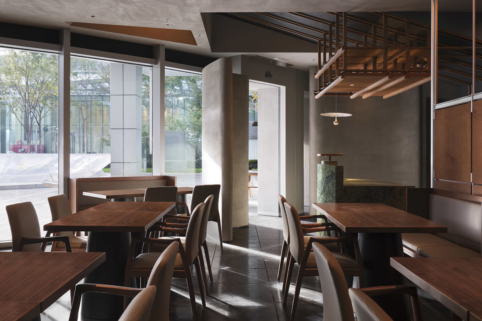 現代餐廳室內,木質餐桌、混凝土地板與金屬點綴。